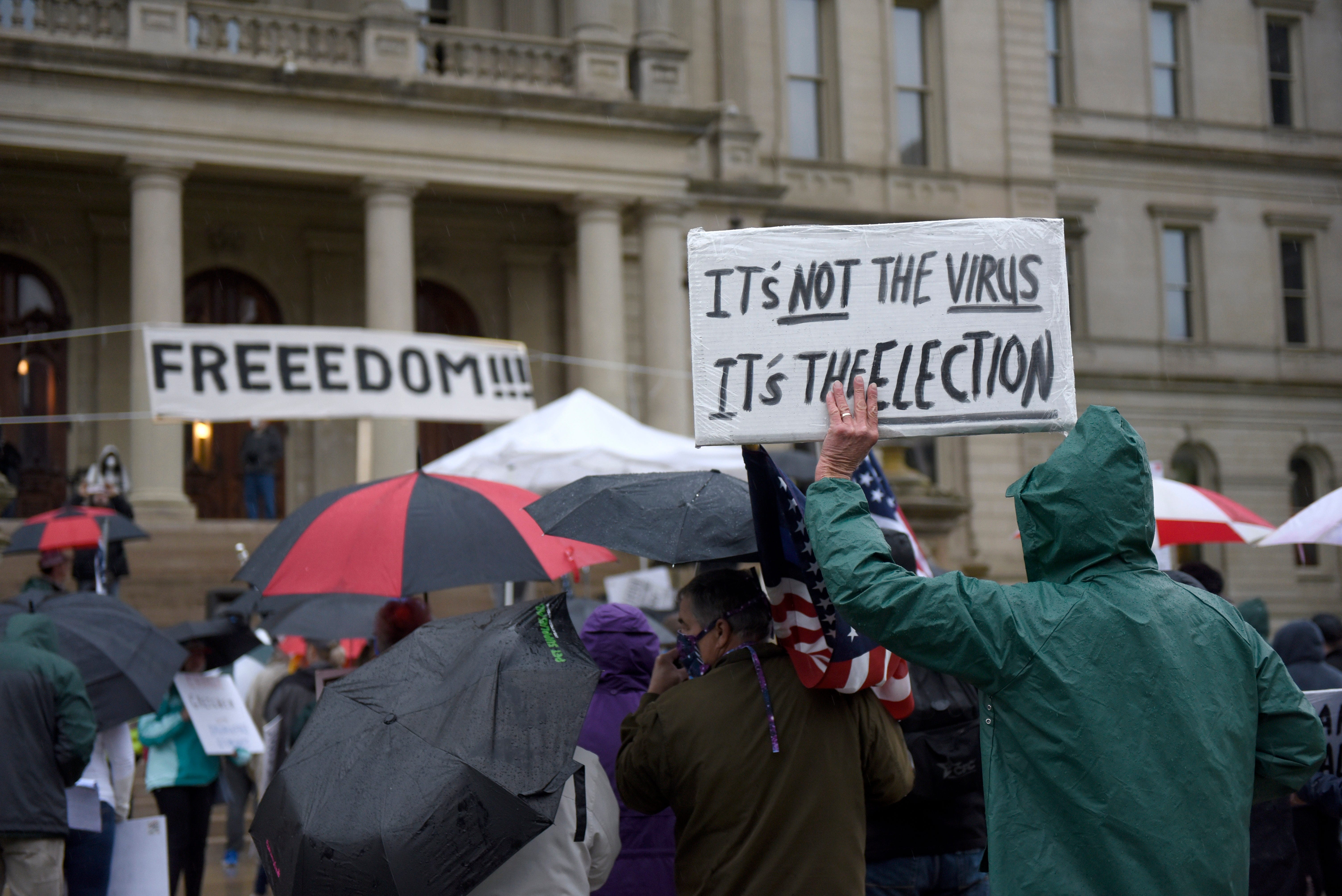 Protesters listen as a speaker addresses a protest at the state Capitol to oppose the executive orders Gov. Gretchen Whitmer issued in response to the coronavirus pandemic, Thursday, May 14, 2020.