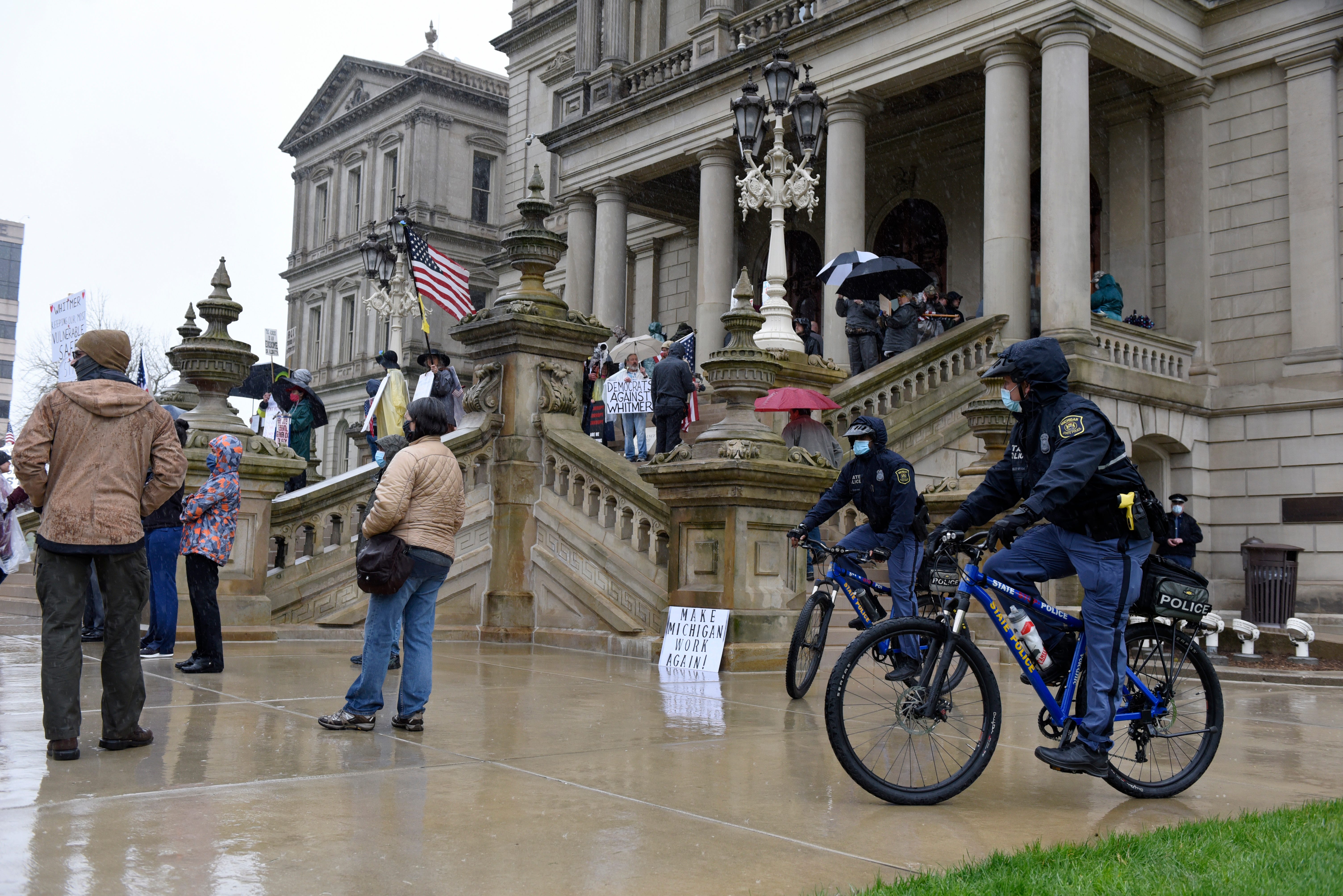 Michigan State Police troopers patrol the protest on bikes.