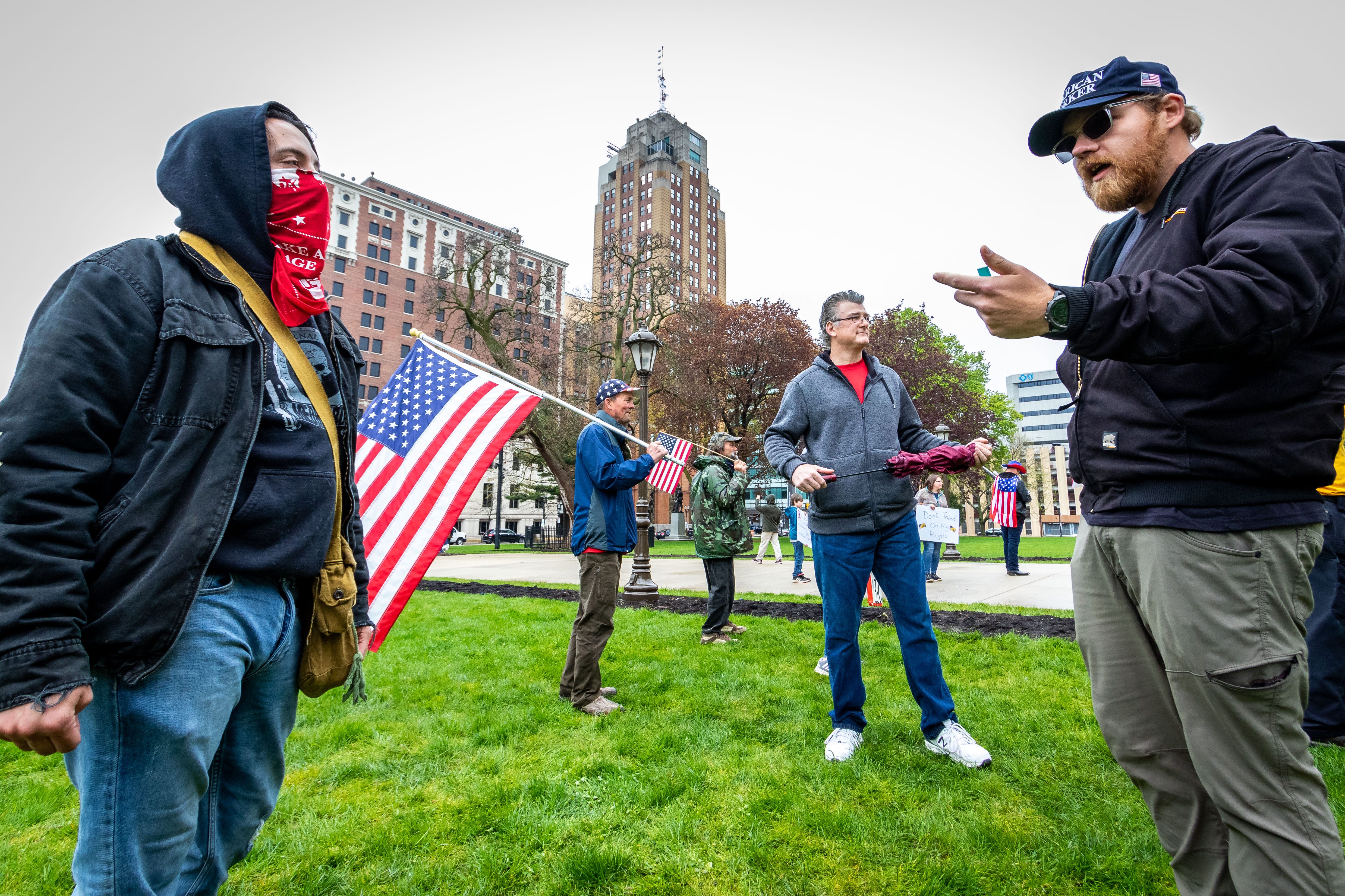 Counter-protestor Ian Engle, left, of Lansing argues with Michigan United for Liberty team member Dylan Montroy, right, of  Sterling Heights on the capitol lawn.