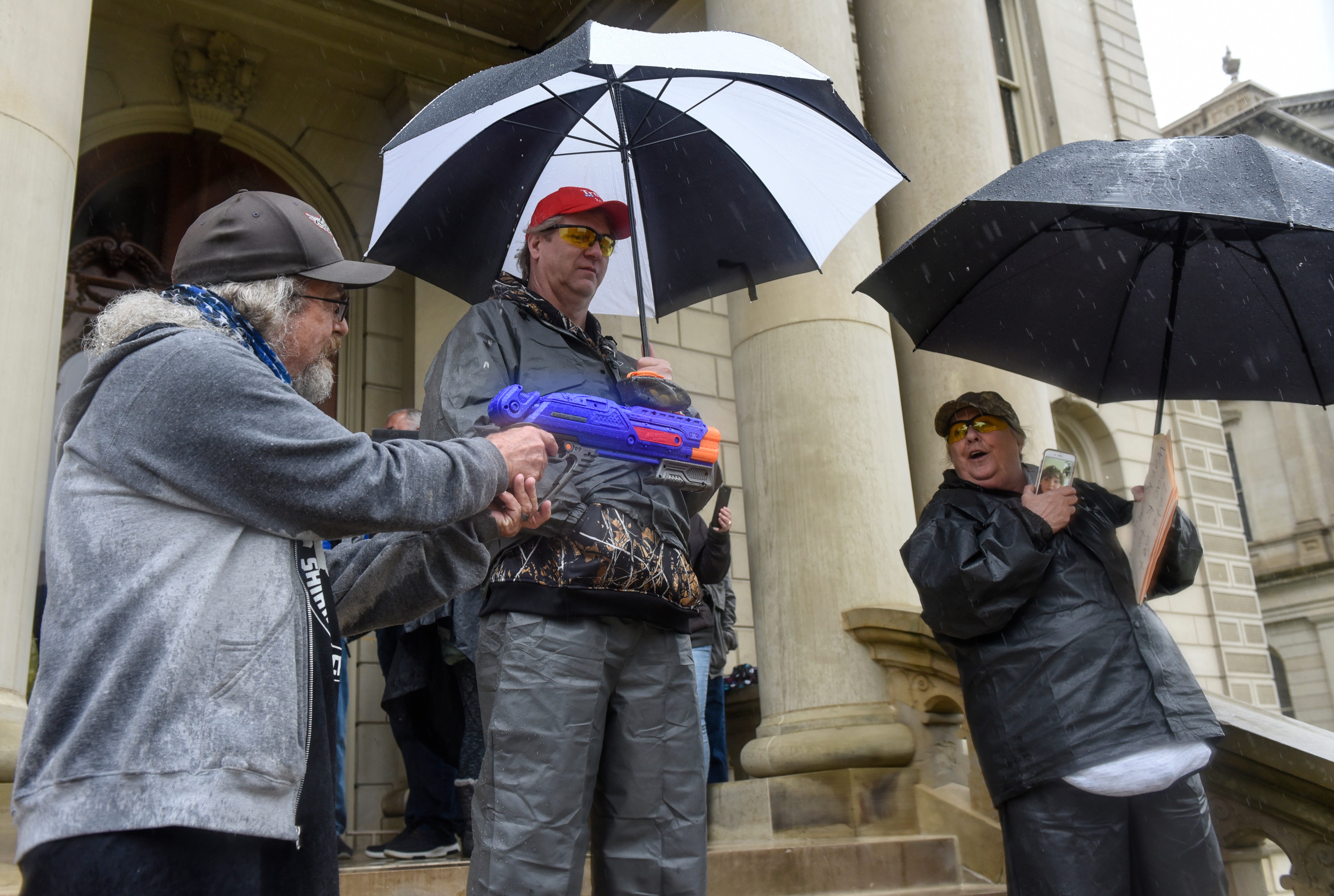 A man who says he founded the Michigan Nerf Militia to make fun of Michigan militias points a Nerf gun at protesters demonstrating in opposition to the executive orders Gov. Gretchen Whitmer issued in response to the coronavirus pandemic.