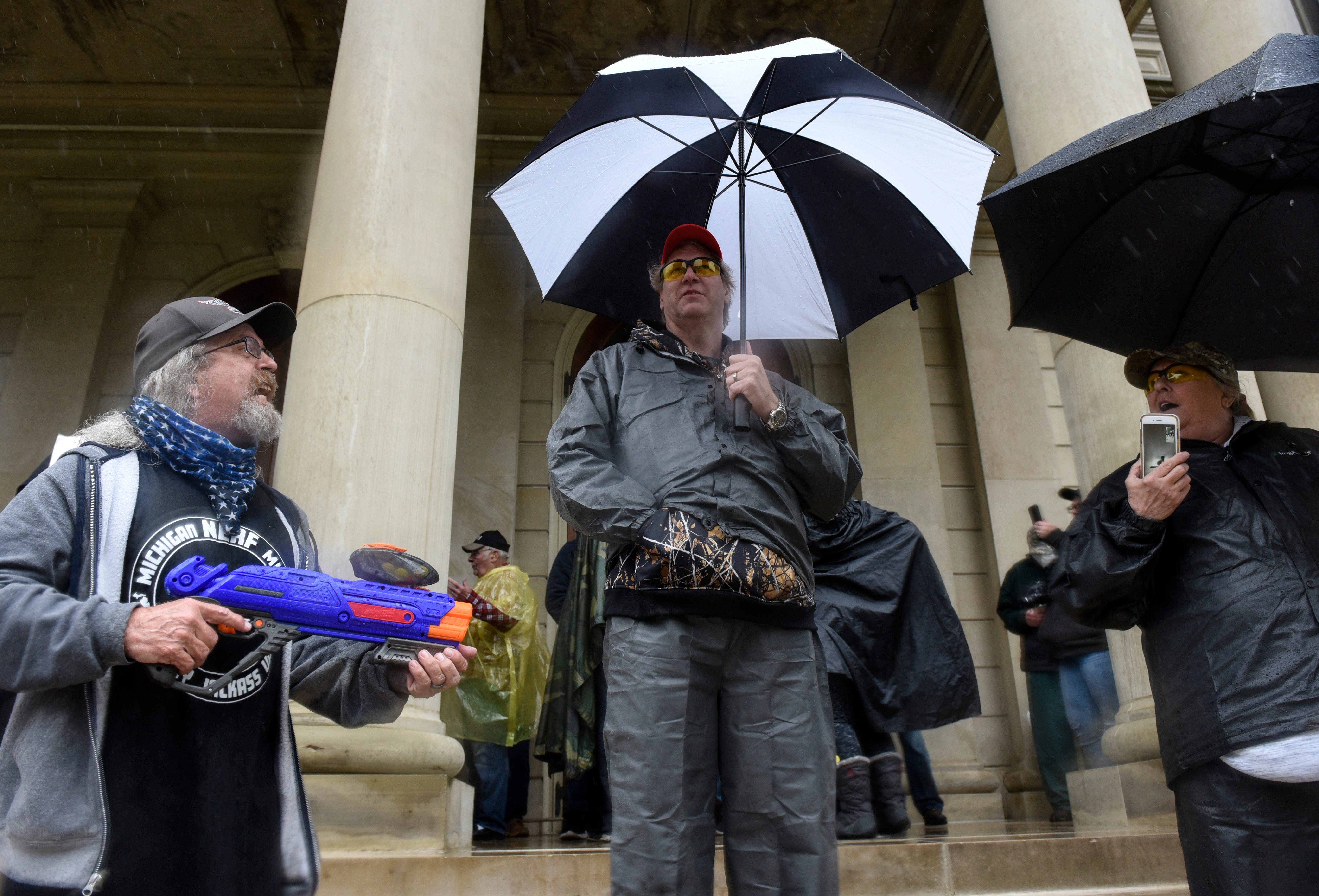 A man who says he founded the Michigan Nerf Militia to make fun of Michigan militias argues with protesters outside the state Capitol building in Lansing.