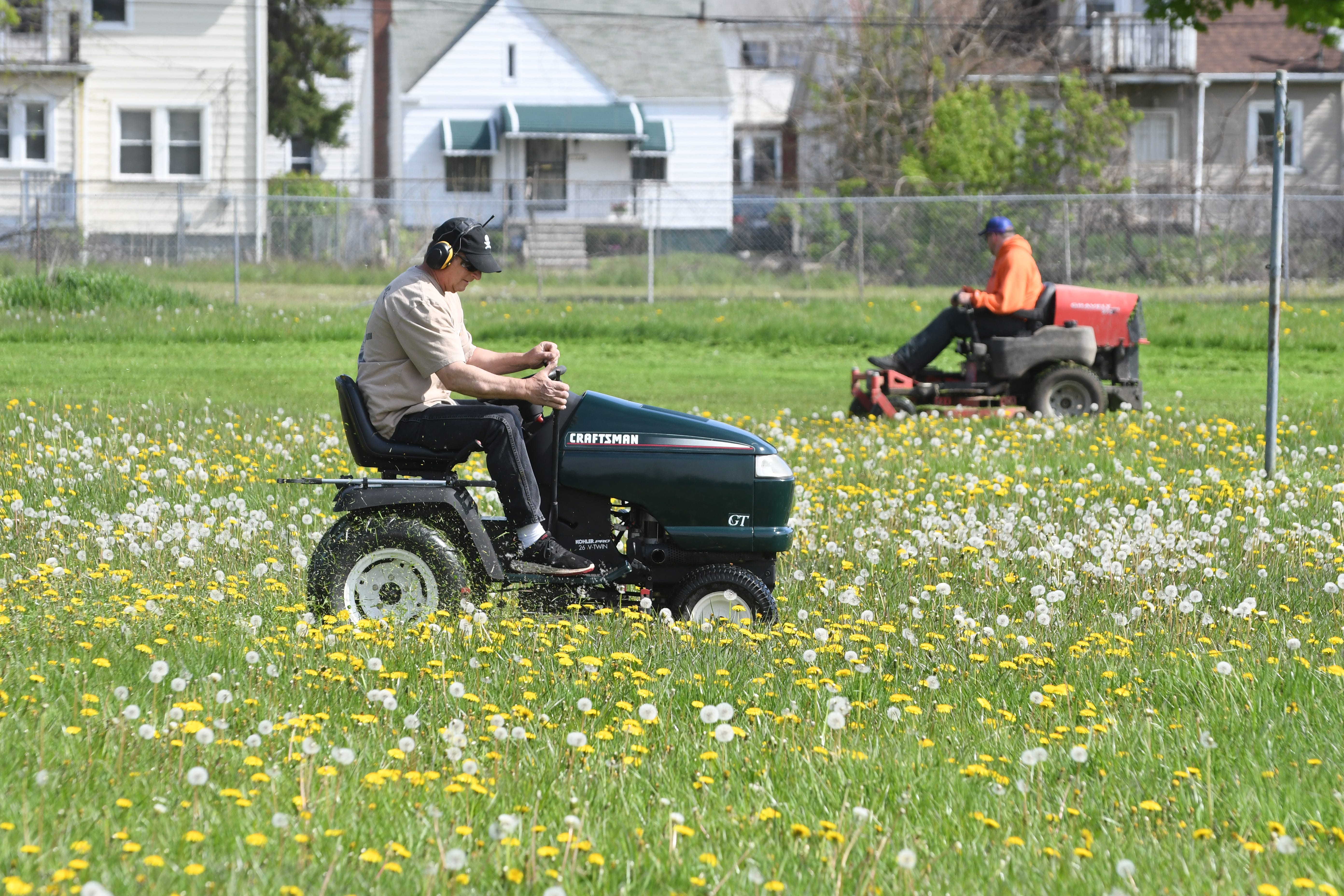 John Dresden, ten-year member of the Detroit Mower Gang, begins mowing the overgrown grass at Hammerberg Playfield in Detroit during a 12- hour mowing marathon.