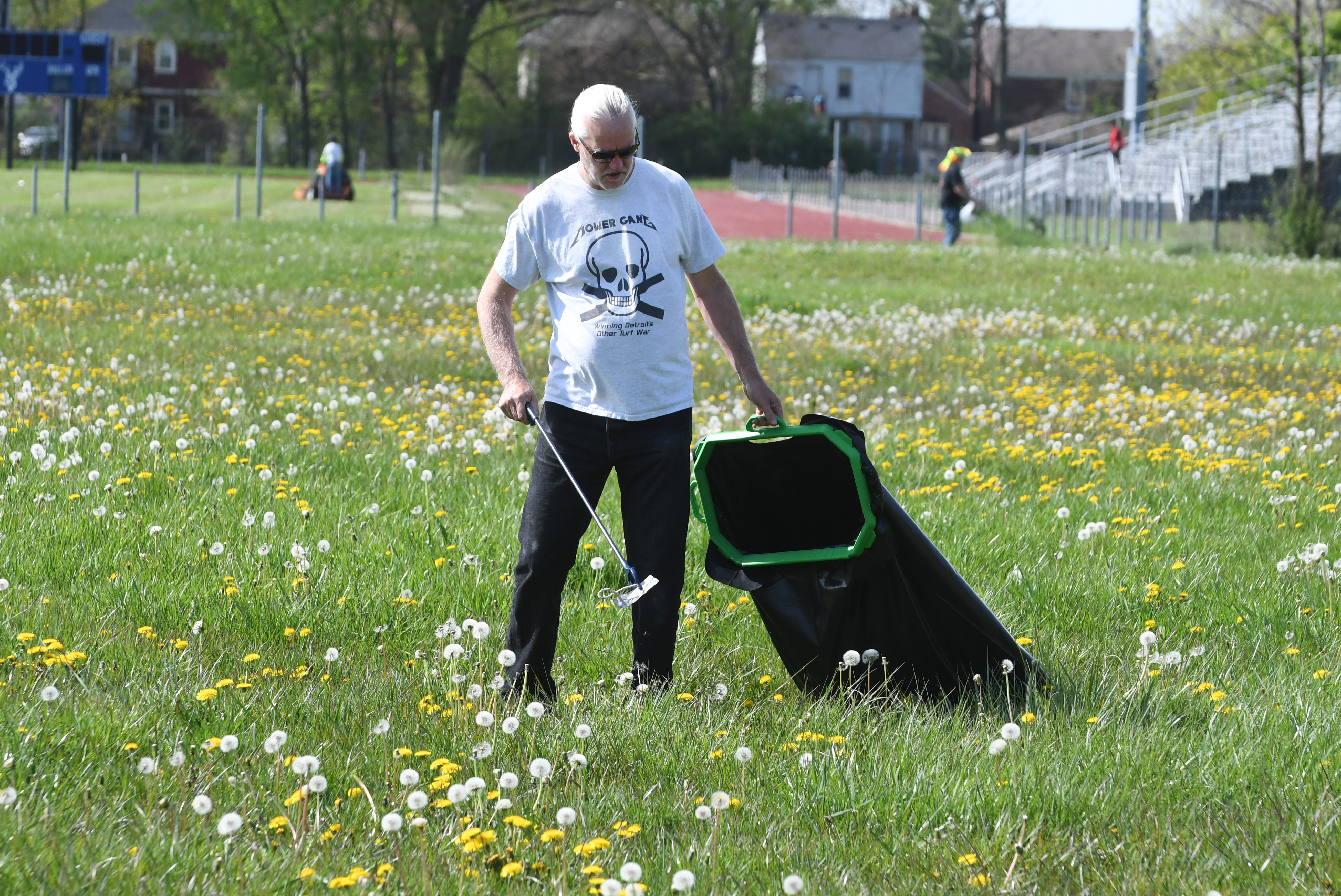 Bill Lucas, volunteer,  Detroit Mower Gang, picks up trash at Hammerberg Playfield during the 2020 Motown Mowdown.