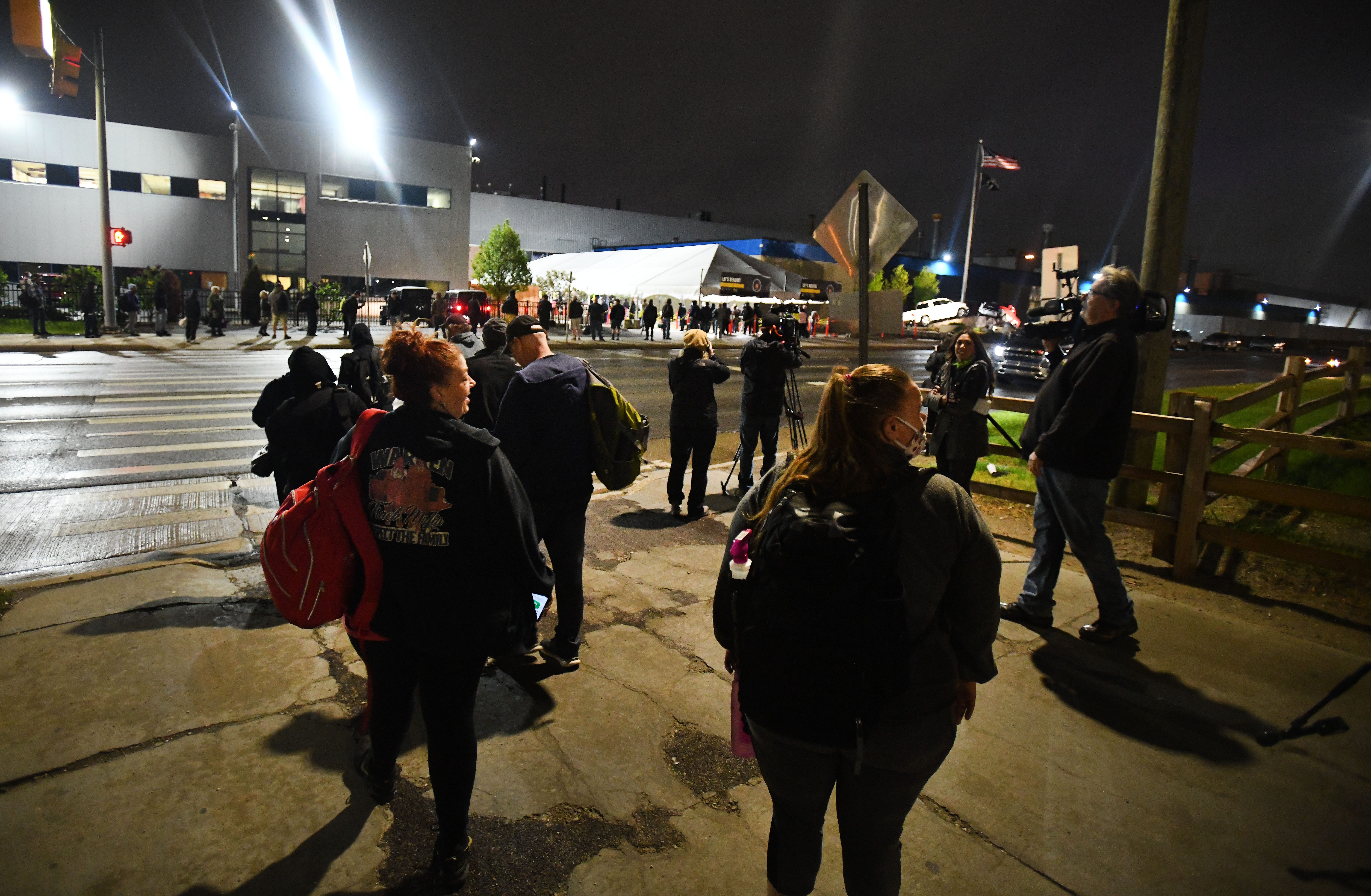 Employees wait in line at 4 am as they arrive at the employee entrance at FCA Warren Truck Assembly in Warren, Michigan on May 18, 2020.