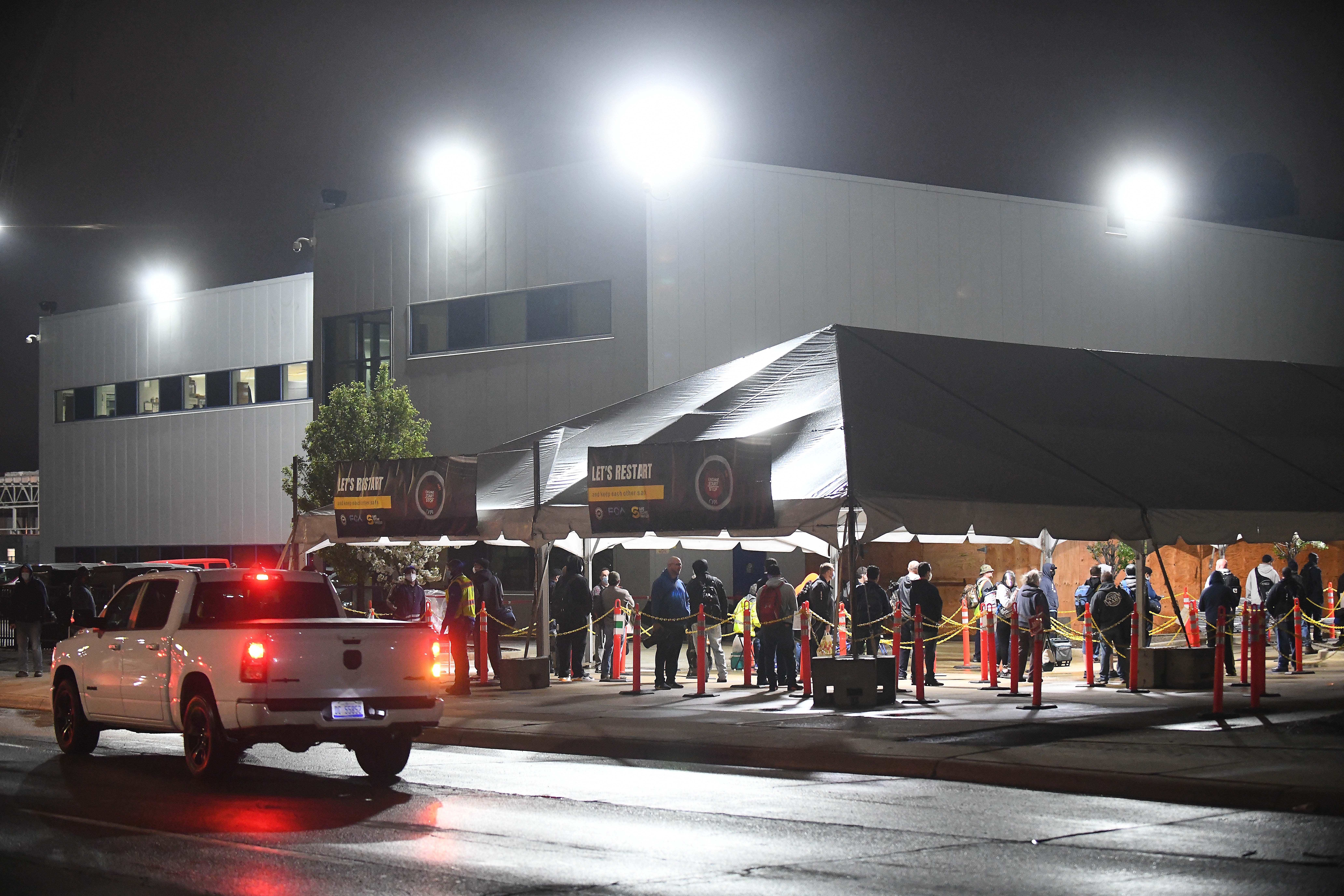 Employees wait in line at 4 am as they arrive at the FCA employee entrance at Warren Truck Assembly in Warren, Michigan early Monday morning, May 18, 2020.