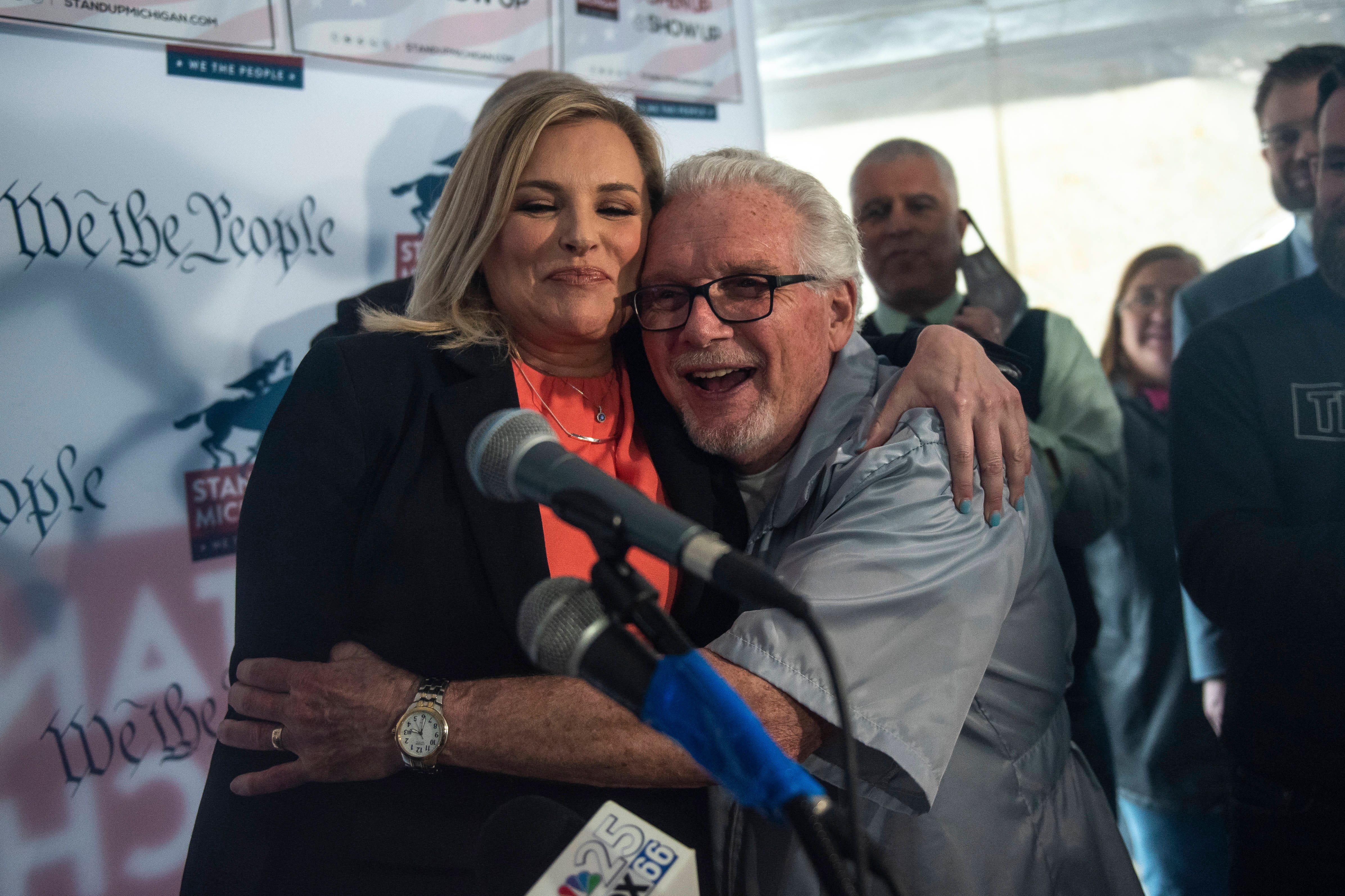 North Dallas, Texas salon owner Shelley Luther, left, and Owosso barber Karl Manke embrace during the press conference.