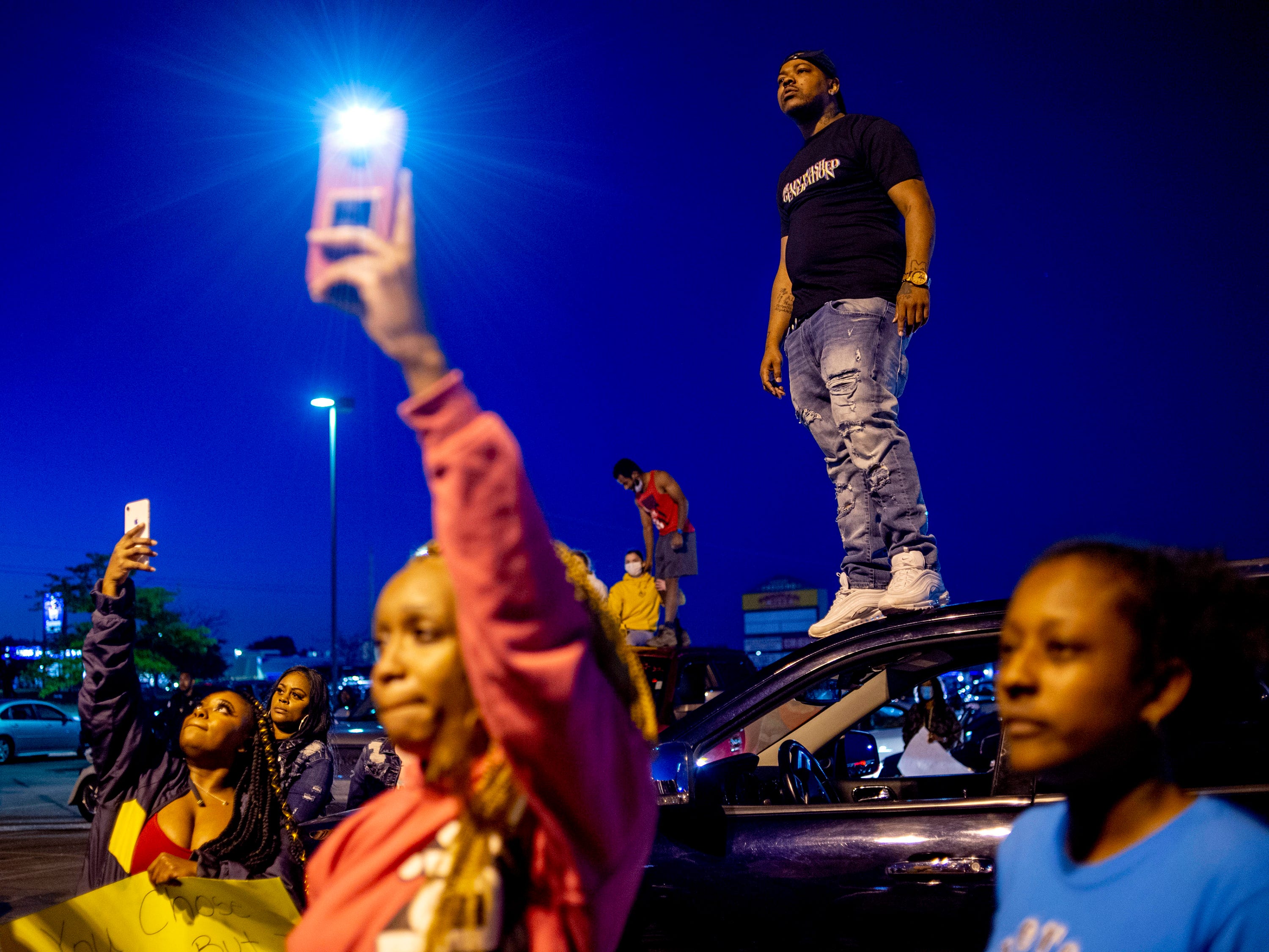 Darrell Campbell of Flint stands atop a vehicle as hundreds protest peacefully, seeking justice for George Floyd on Saturday, May 30, 2020 on Miller Road in Flint Township, M.I. Floyd died in police custody on Memorial Day in Minneapolis.