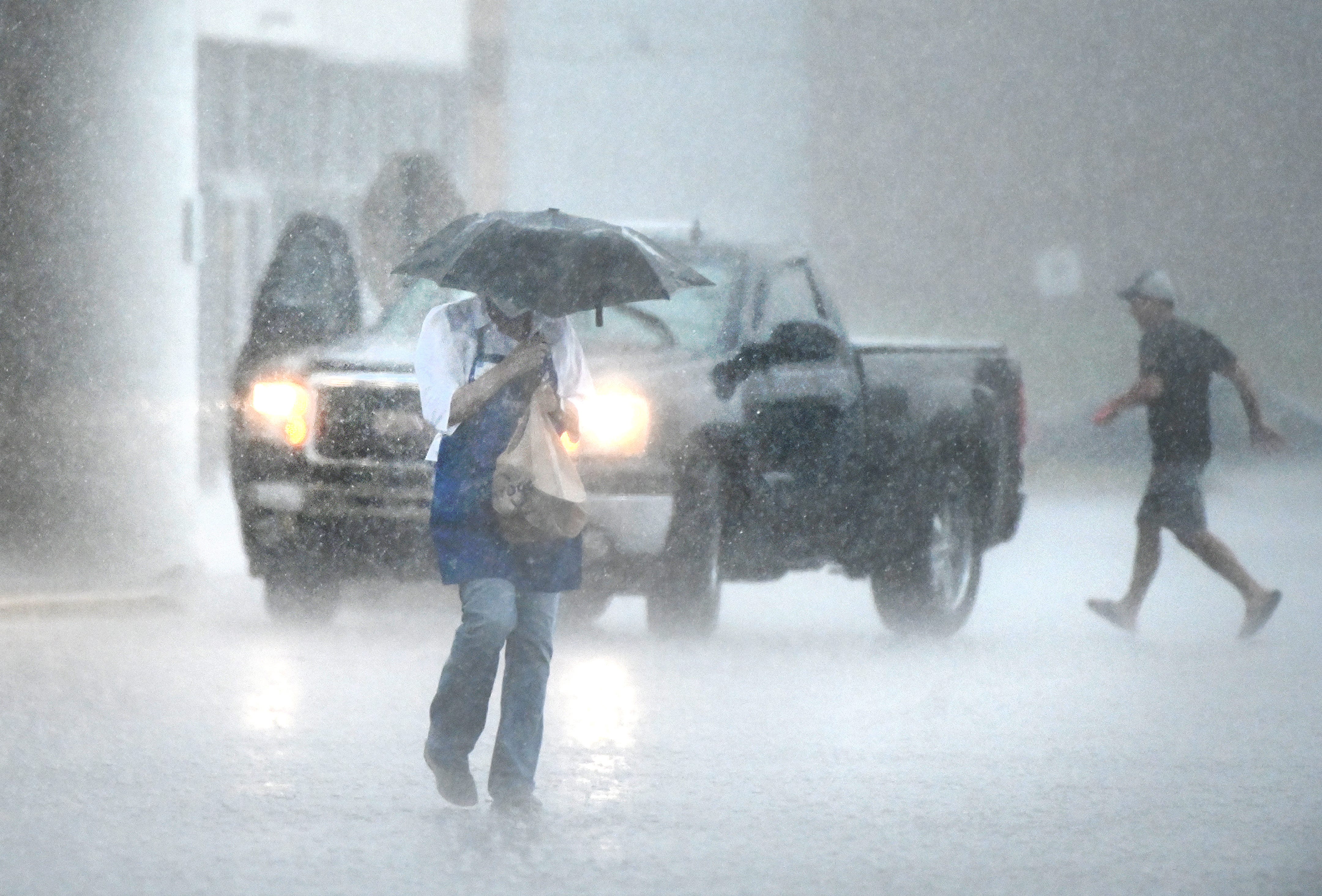 Heavy rain hits shoppers outside a Kroger supermarket in Warren on Wednesday, June 10, 2020.