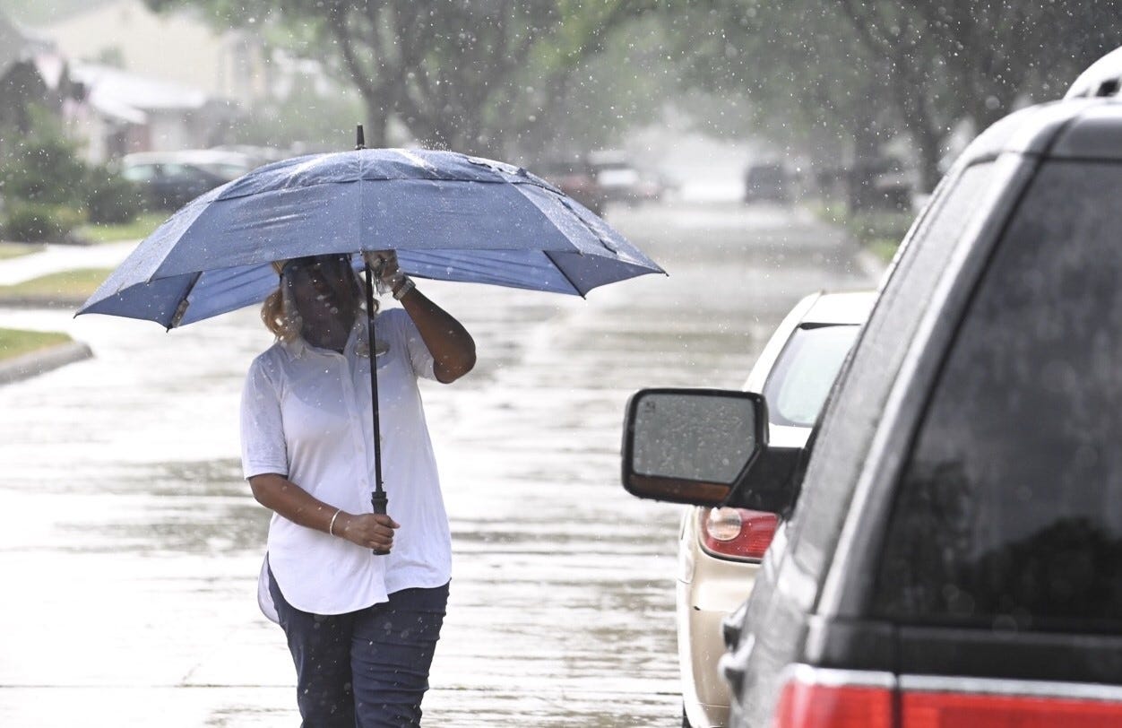 Chandra Graves walks towards her vehicle on Salisbury Street as heavy rain begins to fall in St. Clair Shores on Wednesday, June 10, 2020.