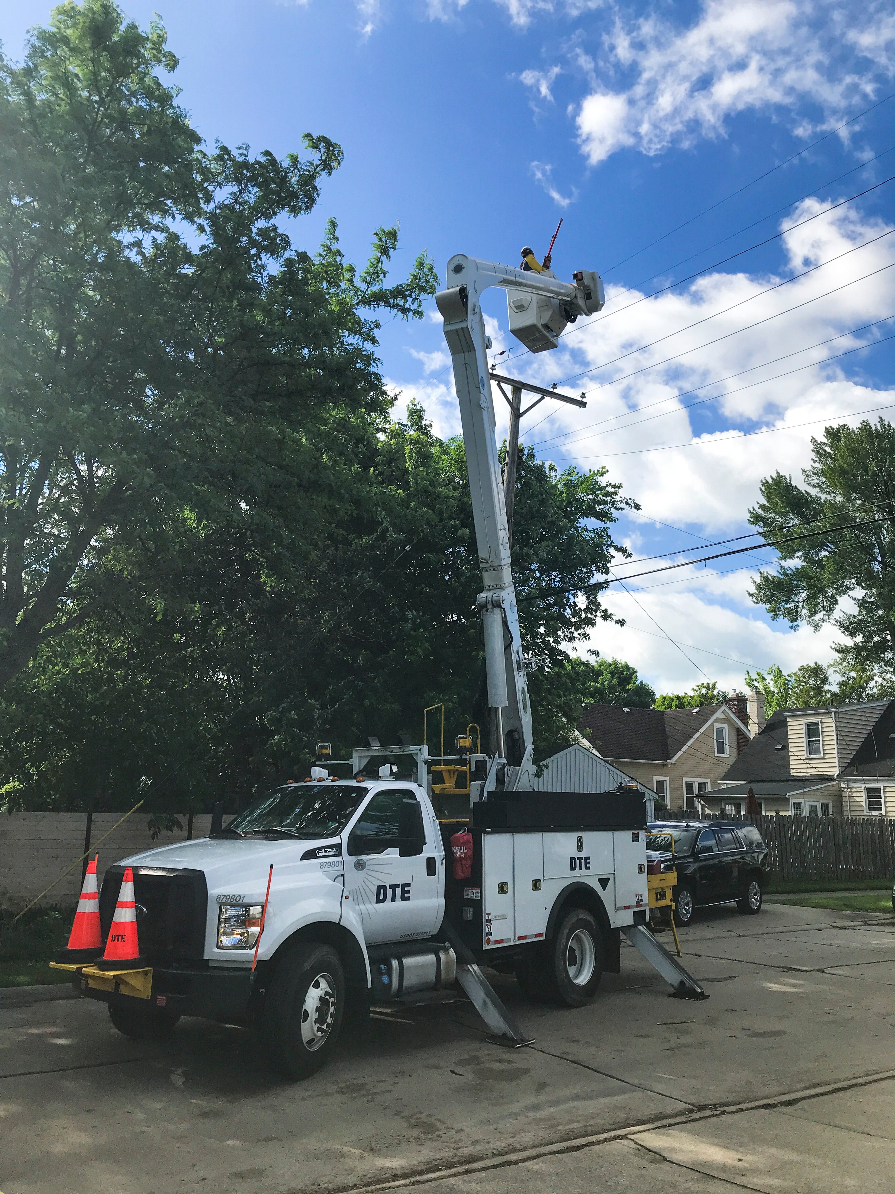 A DTE crew works on restoring power to damaged power lines along Charlevoix Street in Grosse Pointe Woods.