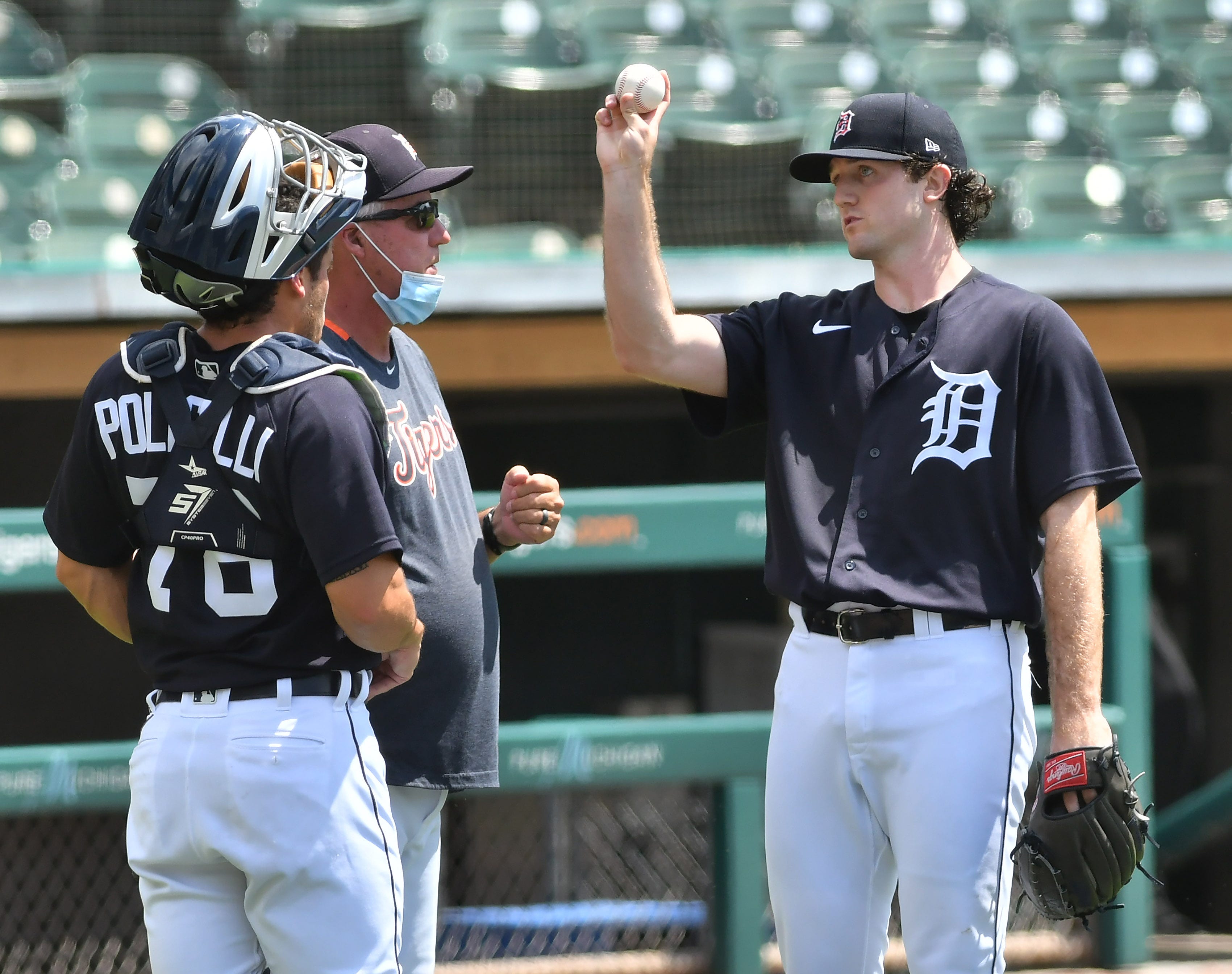 From left, Brady Policelli, Tigers pitching coach Rick Anderson and pitcher Casey Mize talk after Mize throws live batting practice.
