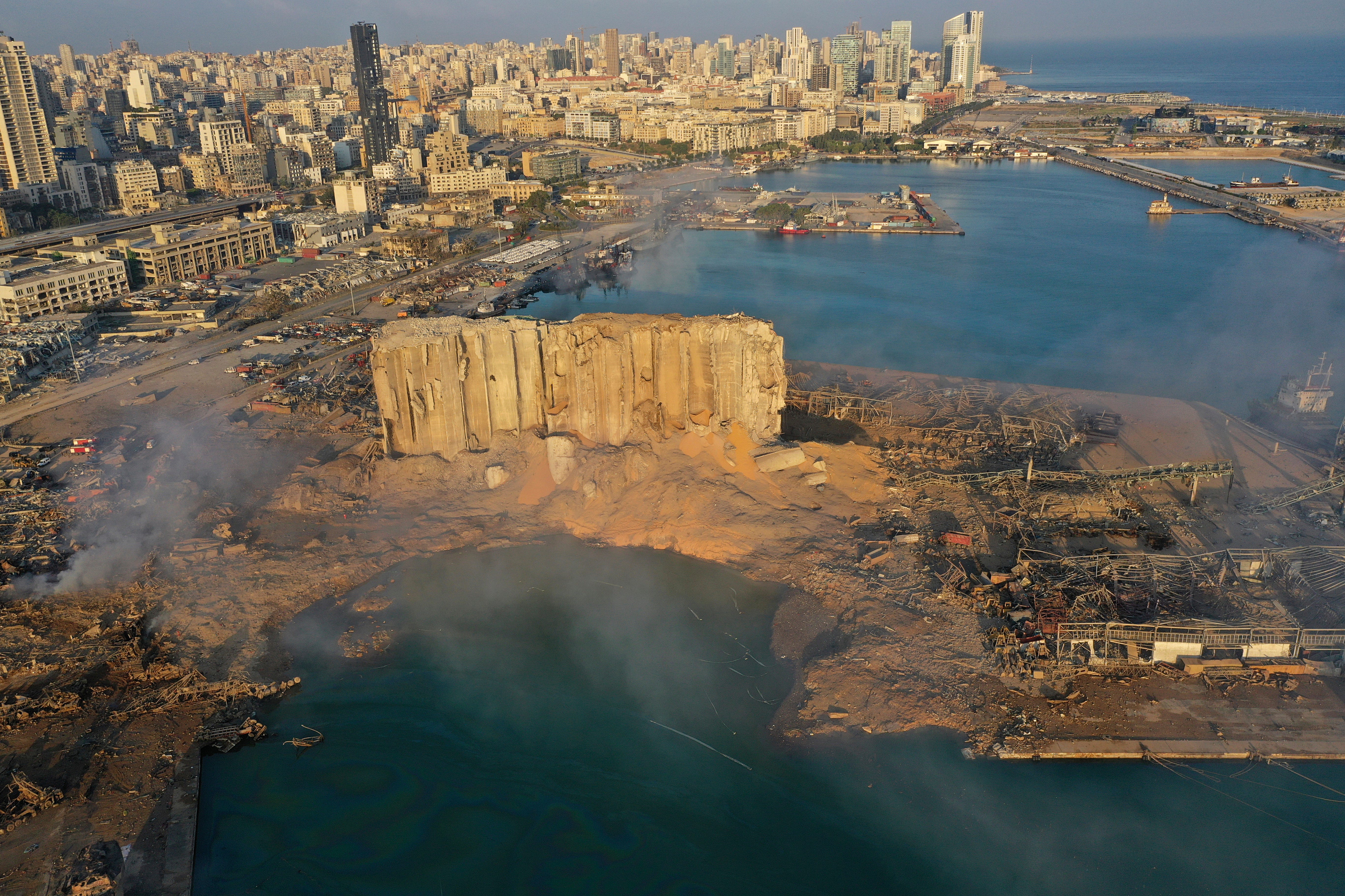 A drone picture shows the scene of an explosion that hit the seaport of Beirut, Lebanon, Wednesday, Aug. 5, 2020. A massive explosion rocked Beirut on Tuesday, flattening much of the city's port, damaging buildings across the capital and sending a giant mushroom cloud into the sky.