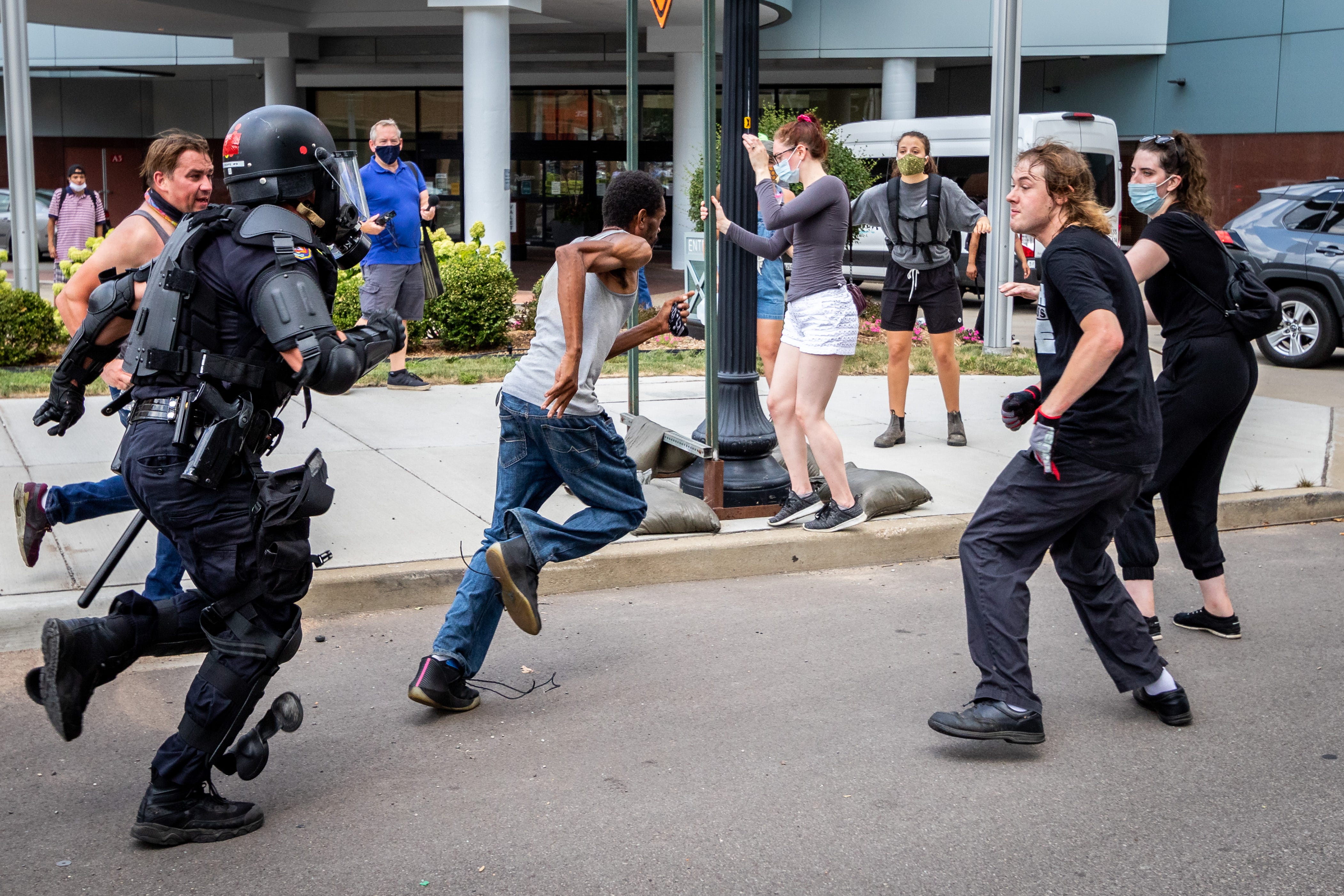 Kalamazoo Police chase a counter-protestor. Members of Proud Boys, antifa, and a local church clash with each other and local and Michigan State Police at Arcadia Creek Festival Plaza in Kalamazoo on August 15, 2020.
