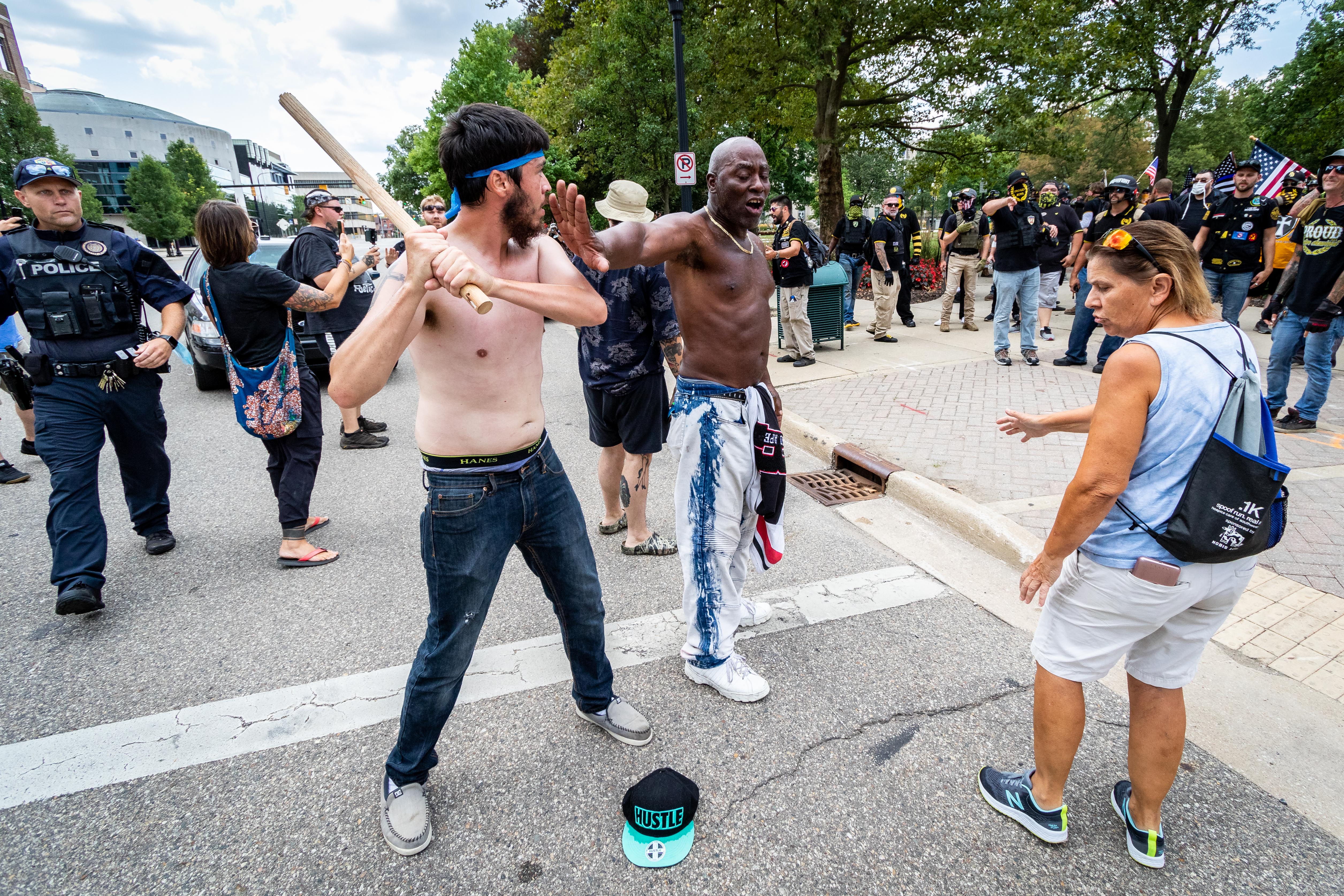 A counter-protester puts a hand up to stop a fellow counter protester from going after Proud Boys members with a stick during a skirmish at Bronson Park in Kalamazoo. Members of Proud Boys, antifa, and a local church clashed with each other and local and Michigan State Police at Arcadia Creek Festival Plaza in Kalamazoo, on Saturday, August 15, 2020.