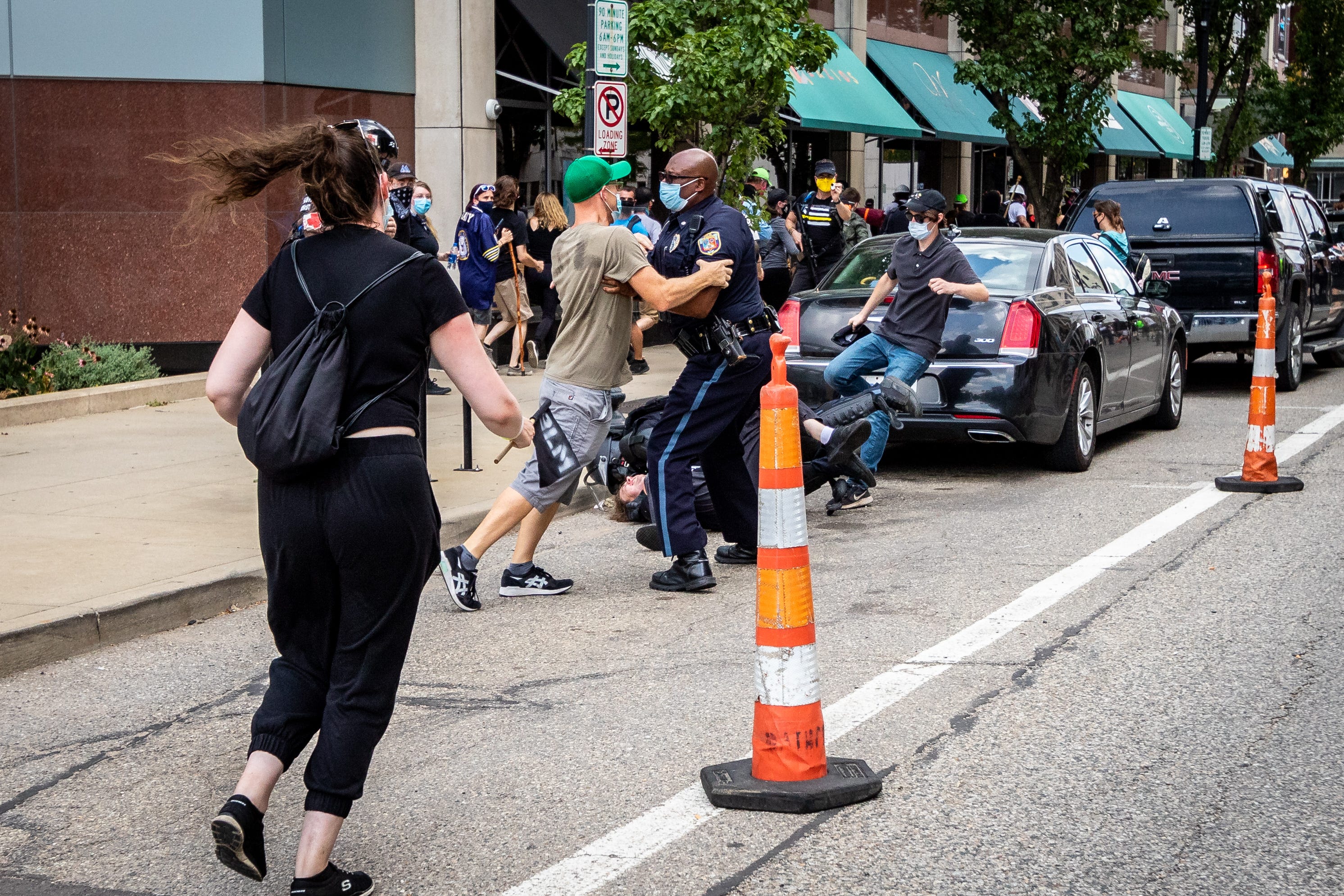 Kalamazoo Assistant Chief of Police, Vernon Coakley, holds back a counter-protestor while another officer makes an arrest. Members of Proud Boys, antifa, and a local church clash with each other and local and Michigan State Police at Arcadia Creek Festival Plaza in Kalamazoo on August 15, 2020.