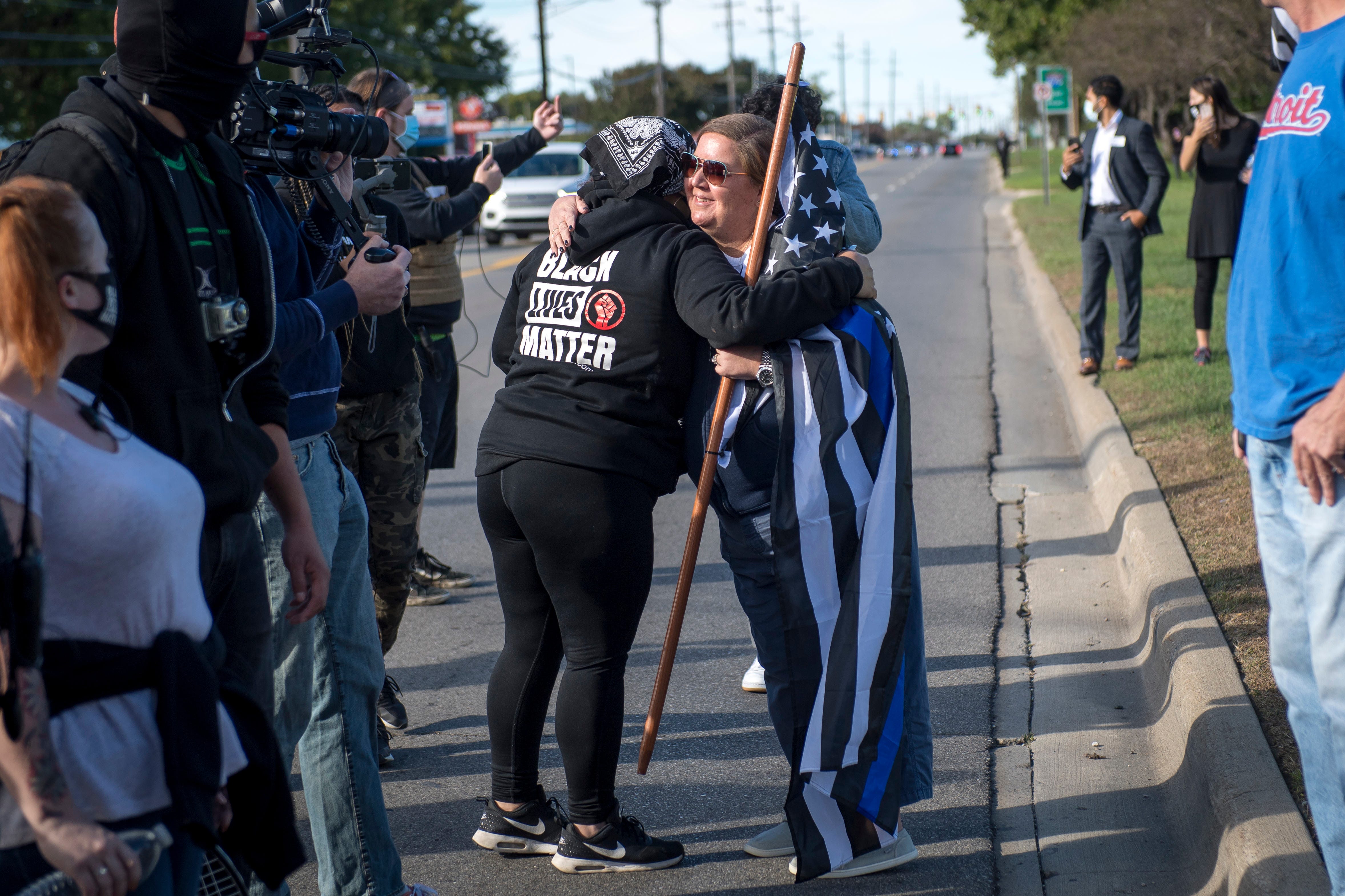 A Detroit Will Breathe protester hugs a Trump supporter before the March Against Racism in Warren on Sept. 19, 2020. The march in Warren occurred in response to the city called hate crimes against residents Candace Hall, her husband Eddie and their two children.