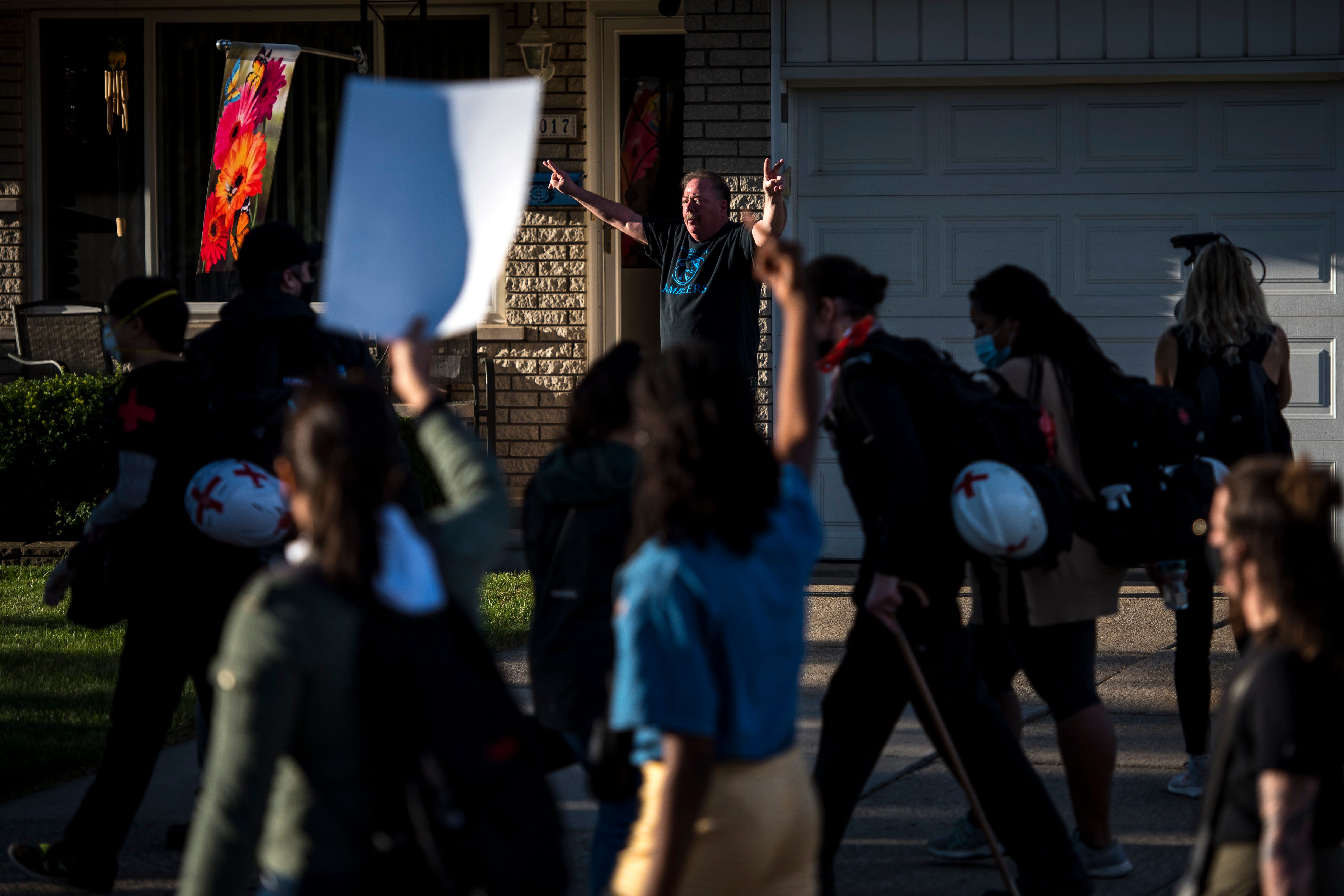 A man yells “Trump!” while protesters march past his home during the March Against Racism in Warren on Sept. 19, 2020. The march in Warren occurred in response to the city called hate crimes against residents Candace Hall, her husband Eddie and their two children.