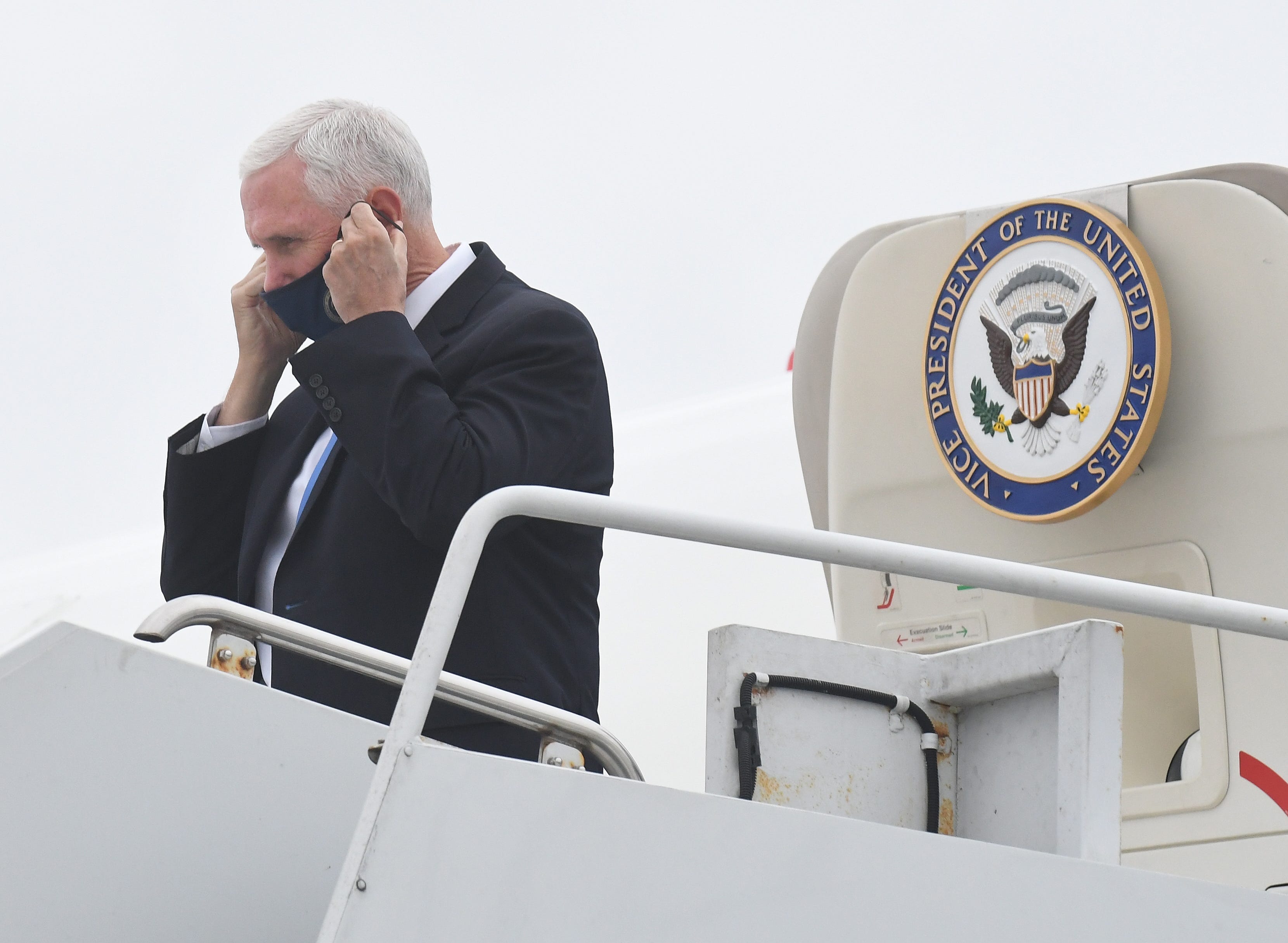 Vice President Mike Pence puts his mask on after arriving to Gerald R. Ford International Airport in Air Force 2 for a campaign stop in Grand Rapids, Michigan on October 14, 2020.