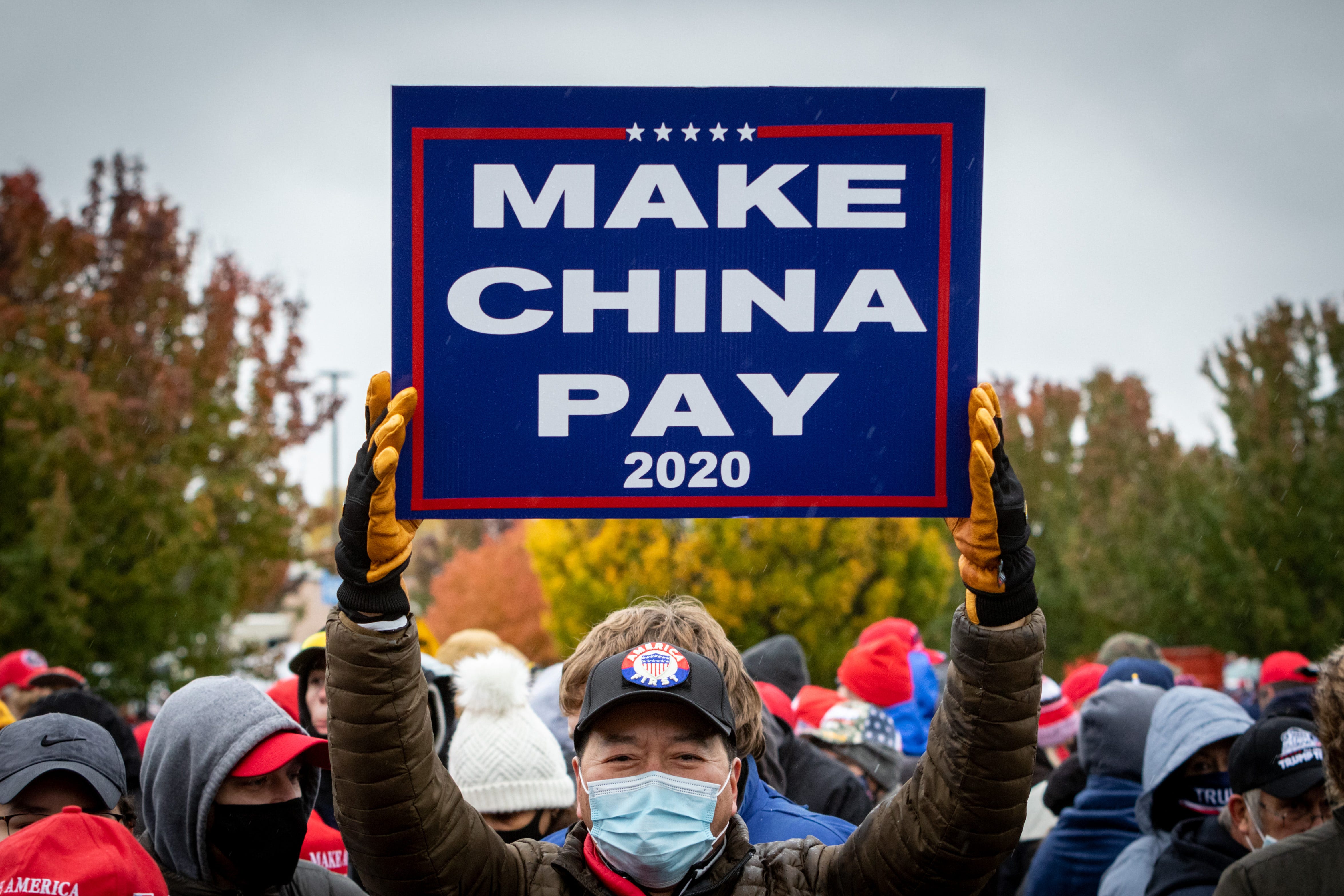 Michale Lee of DeWitt holds a sign in support of Donald Trump's efforts to hold China accountable for their trade practices, espionage, and cybersecurity.