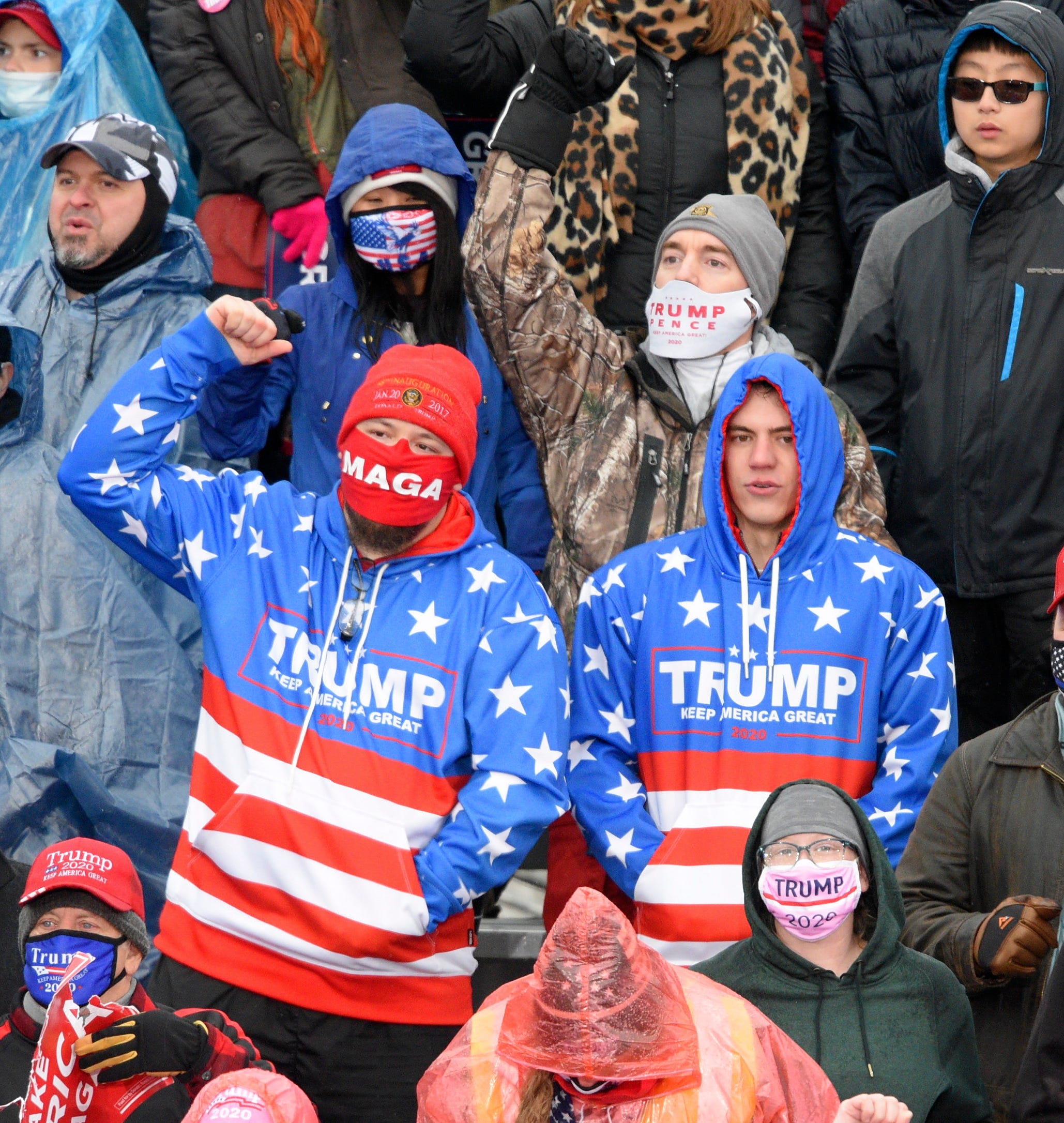 People wear matching Trump jackets as they wait for the President to arrive at a campaign rally in Lansing.