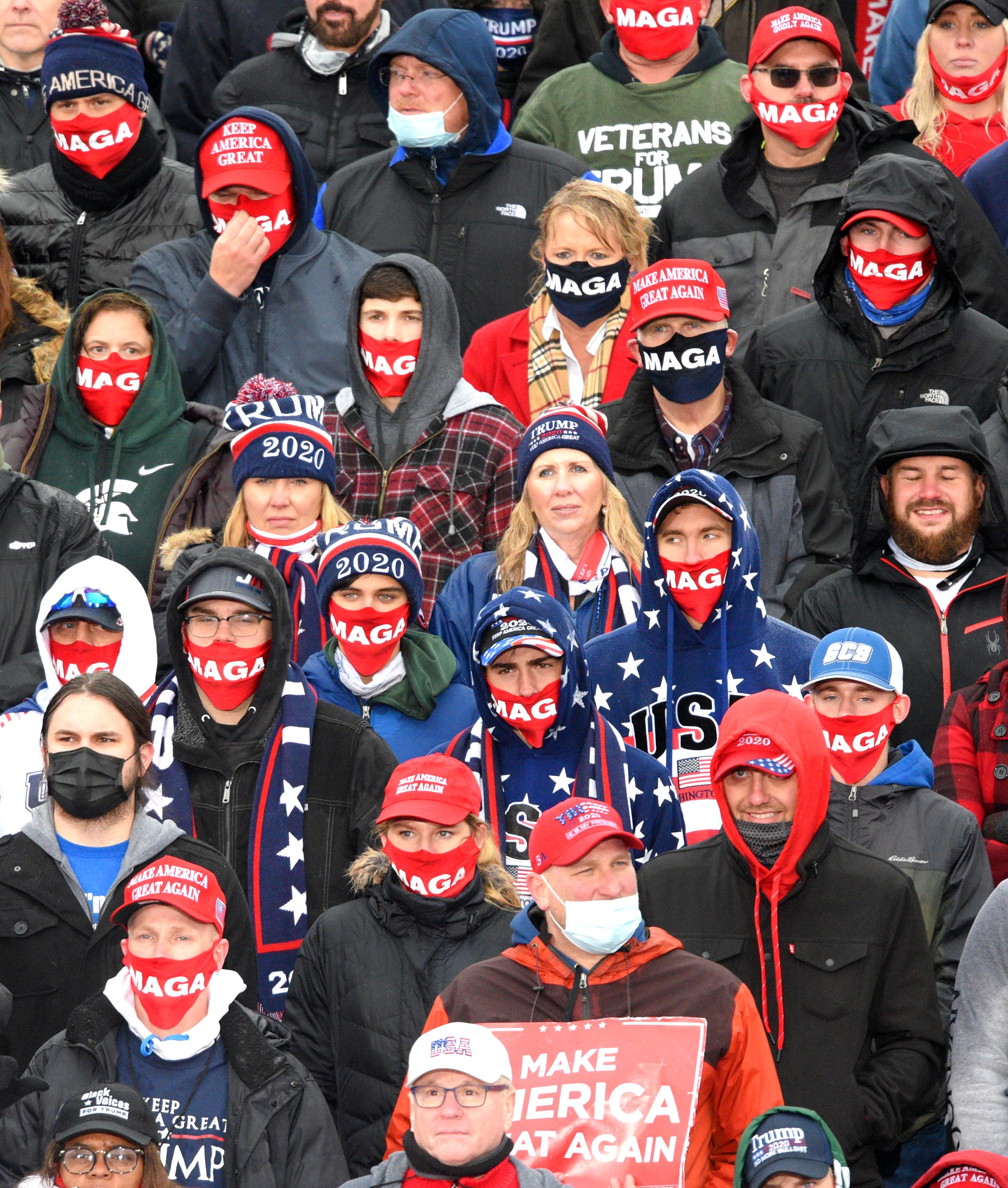 Trump supporters wear MAGA PPE masks during the President's Lansing campaign rally.