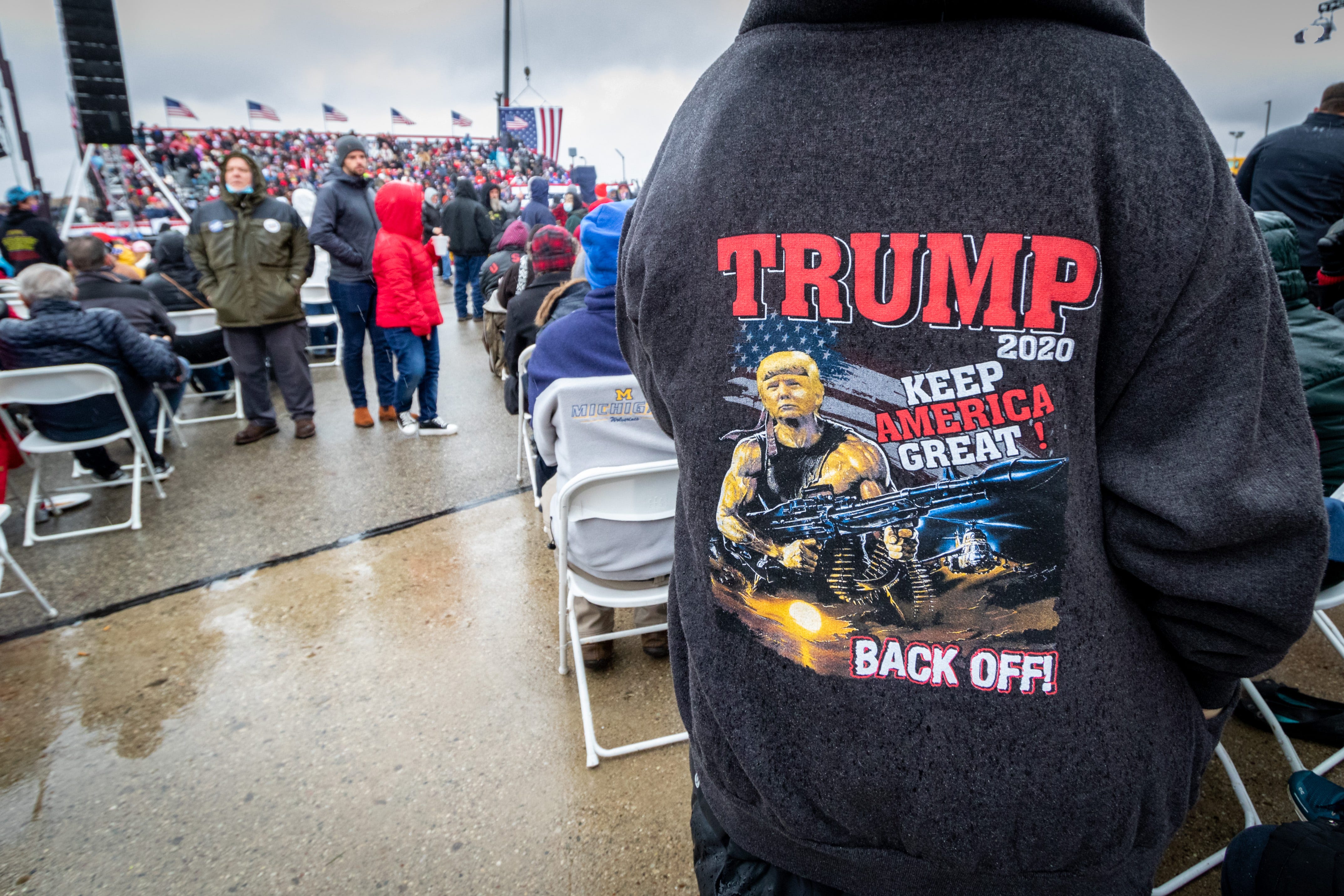 Trump supporters wait in the rain for the Lansing rally to start.