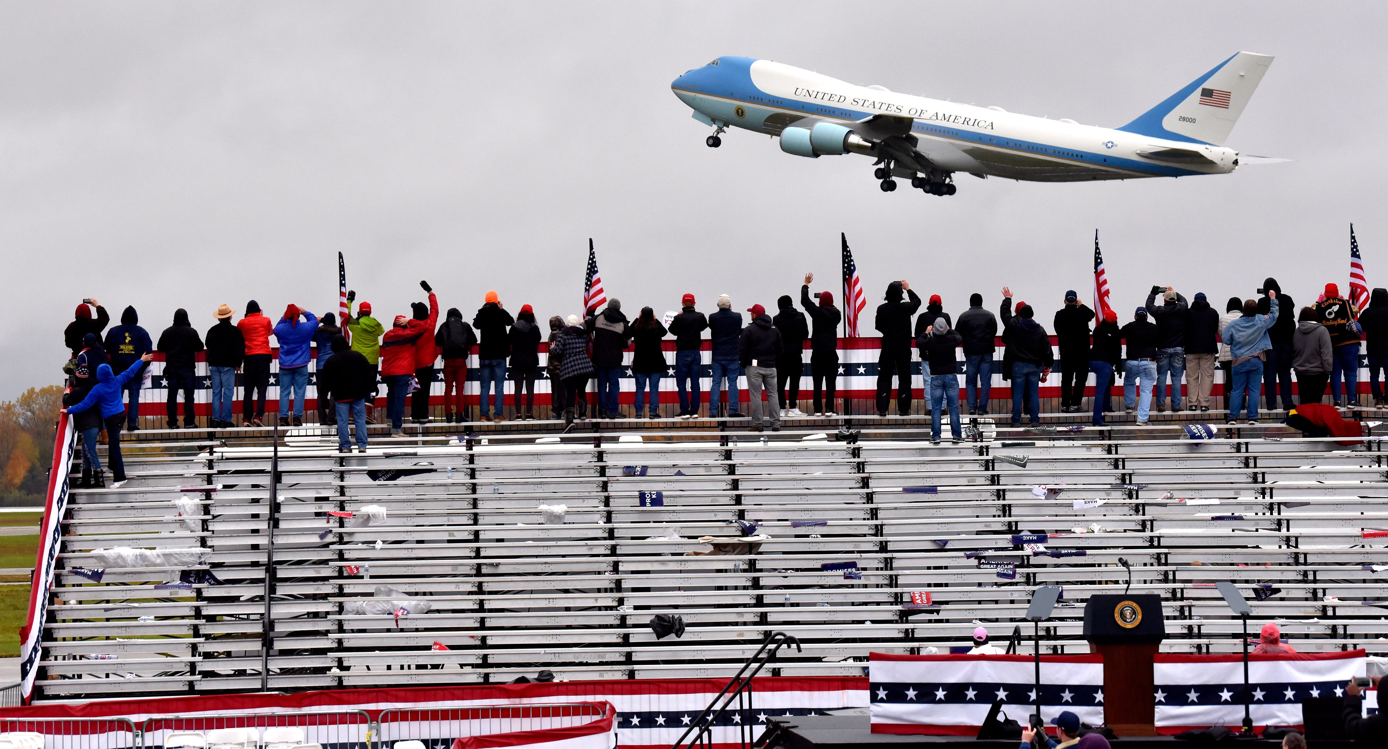 Trump supporters wave as the President flies away aboard Air Force One after his campaign stop in Lansing.