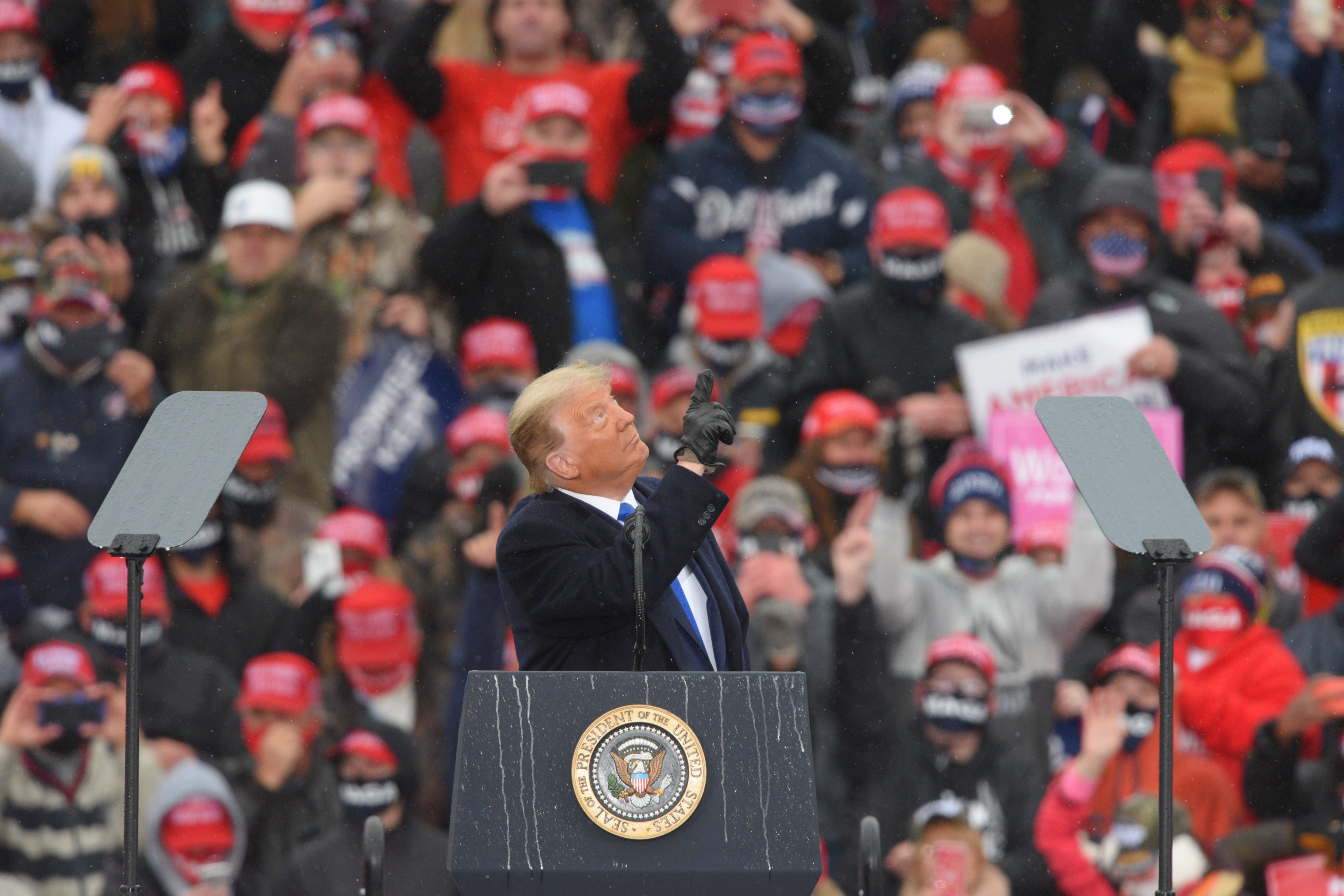 President Trump points towards the sky as the song says "God Bless The USA" during his Make America Great Again Victory Rally at AV Flight at the Capital Region International Airport in Lansing, Tuesday, October 27, 2020.