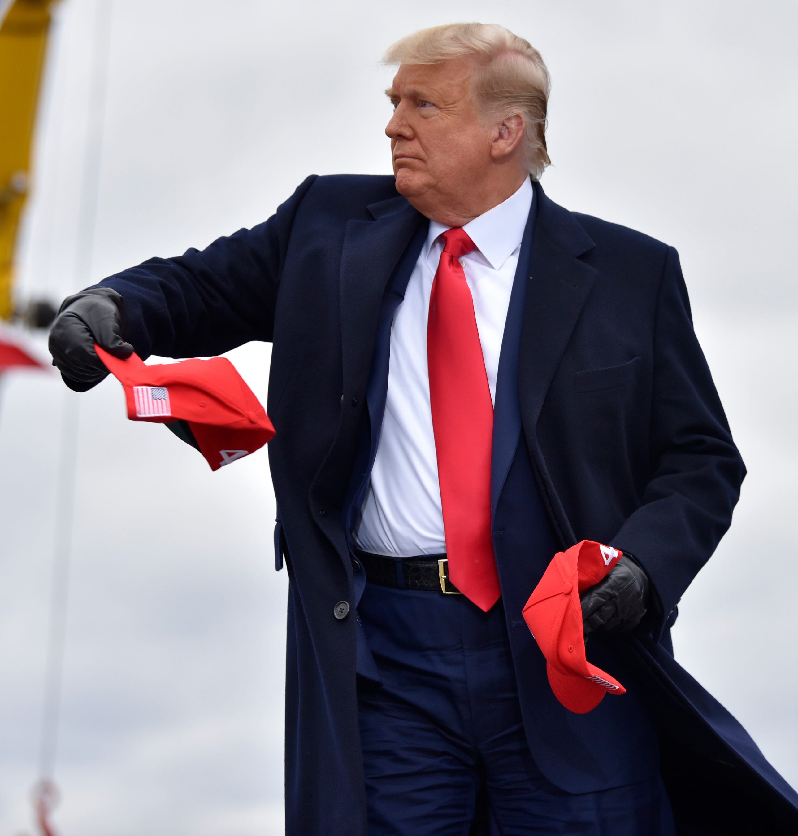 U.S. President Donald Trump throws out hats to the crowd upon his arrival at the Oakland International Airport in Waterford Twp., Friday, October 30, 2020, for his Make America Great Again Victory Rally.