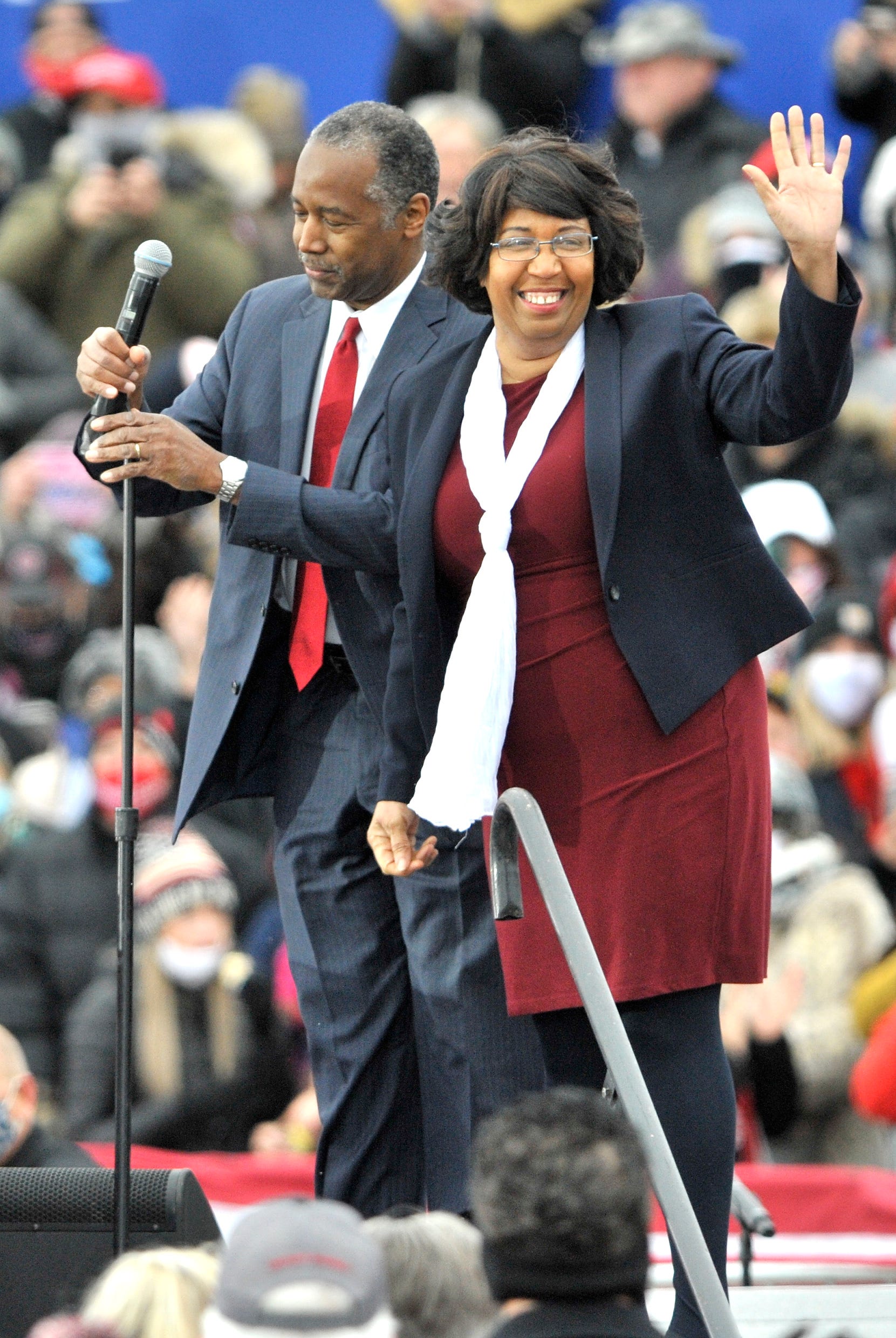 Candy Carson waves on stage with her husband, Ben, before Trump arrives for the rally.