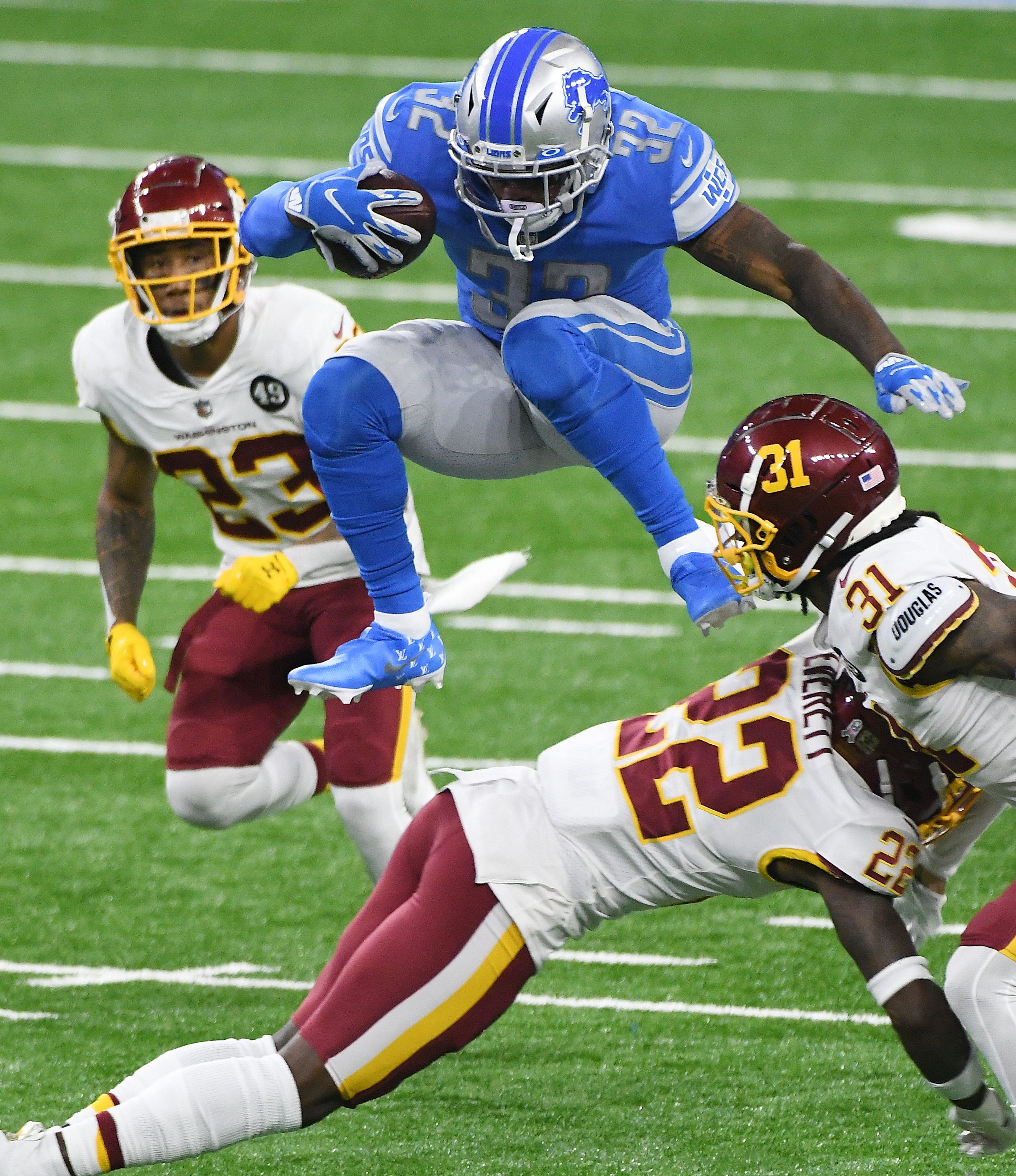 Lions running back D'Andre Swift hurdles Washington's Deshazor Everett on a run in the first quarter of Detroit's 30-27 victory at Ford Field in Detroit on Nov. 15, 2020.