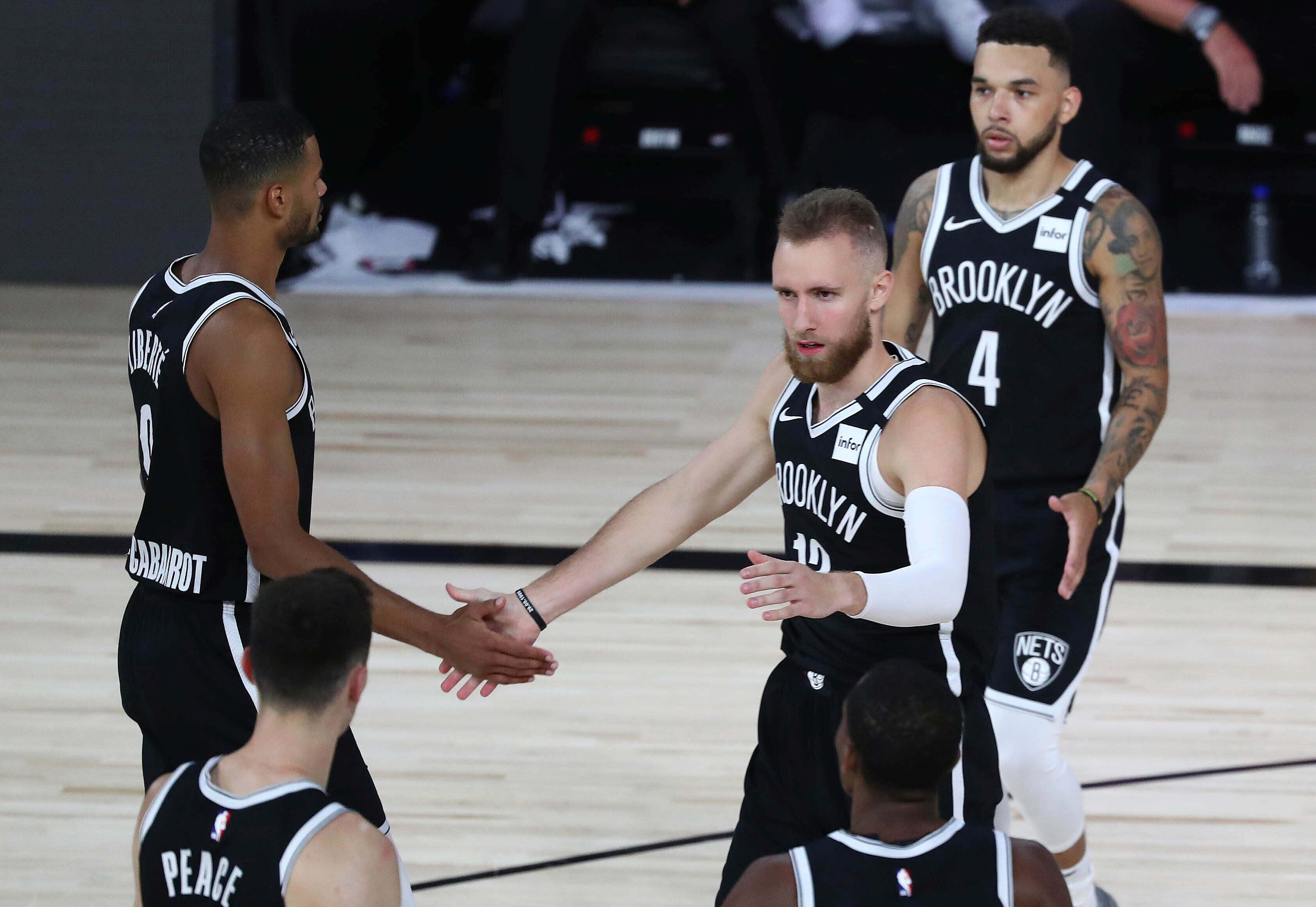 Brooklyn Nets guard Dzanan Musa (13) is congratulated after scoring a basket and drawing a foul against the Toronto Raptors during the second half of Game 4 of an NBA basketball first-round playoff series, Sunday, Aug. 23, 2020, in Lake Buena Vista, Fla.