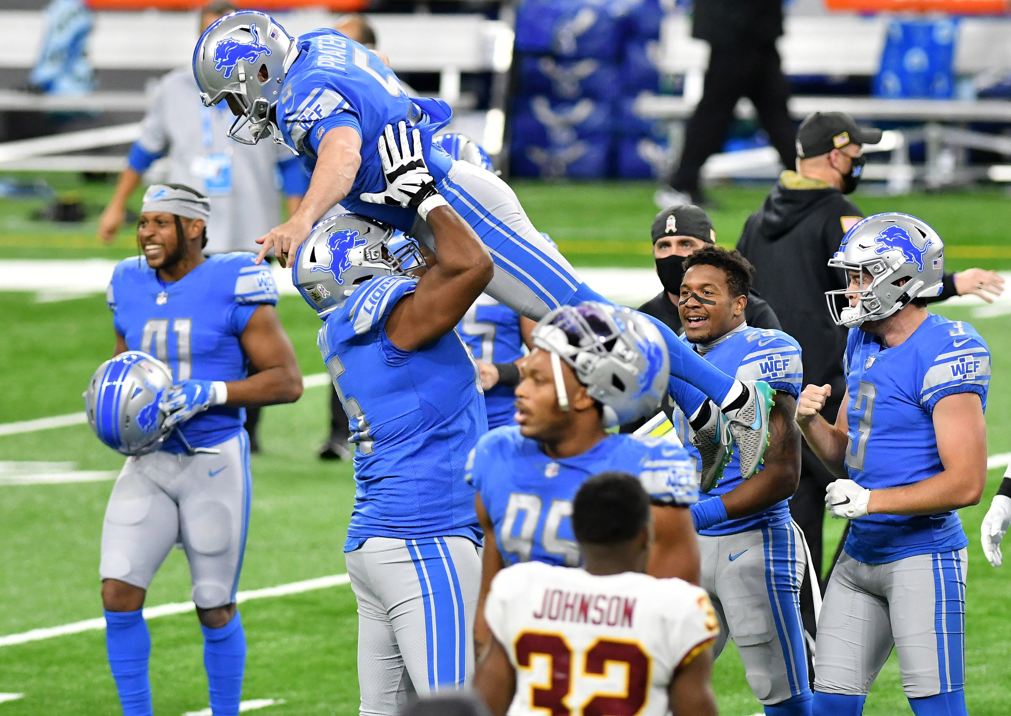 Lions' Tyrell Crosby celebrates with kicker Matt Prater after the win in the fourth quarter.
