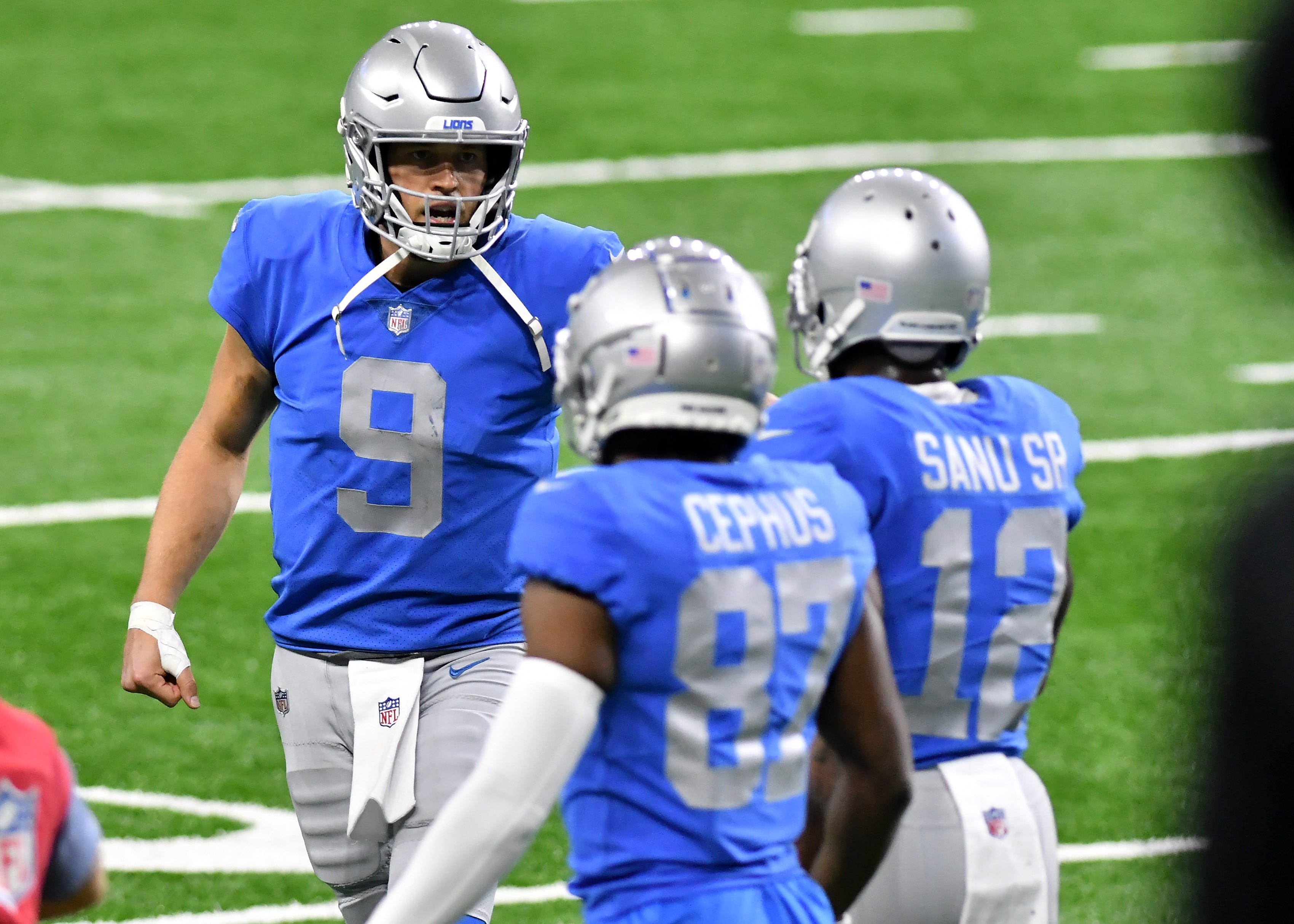 Lions quarterback Matthew Stafford (9) talks with wide receivers Mohamed Sanu (12) and Quintez Cephus (87) after they score the two-point conversion in the fourth quarter.