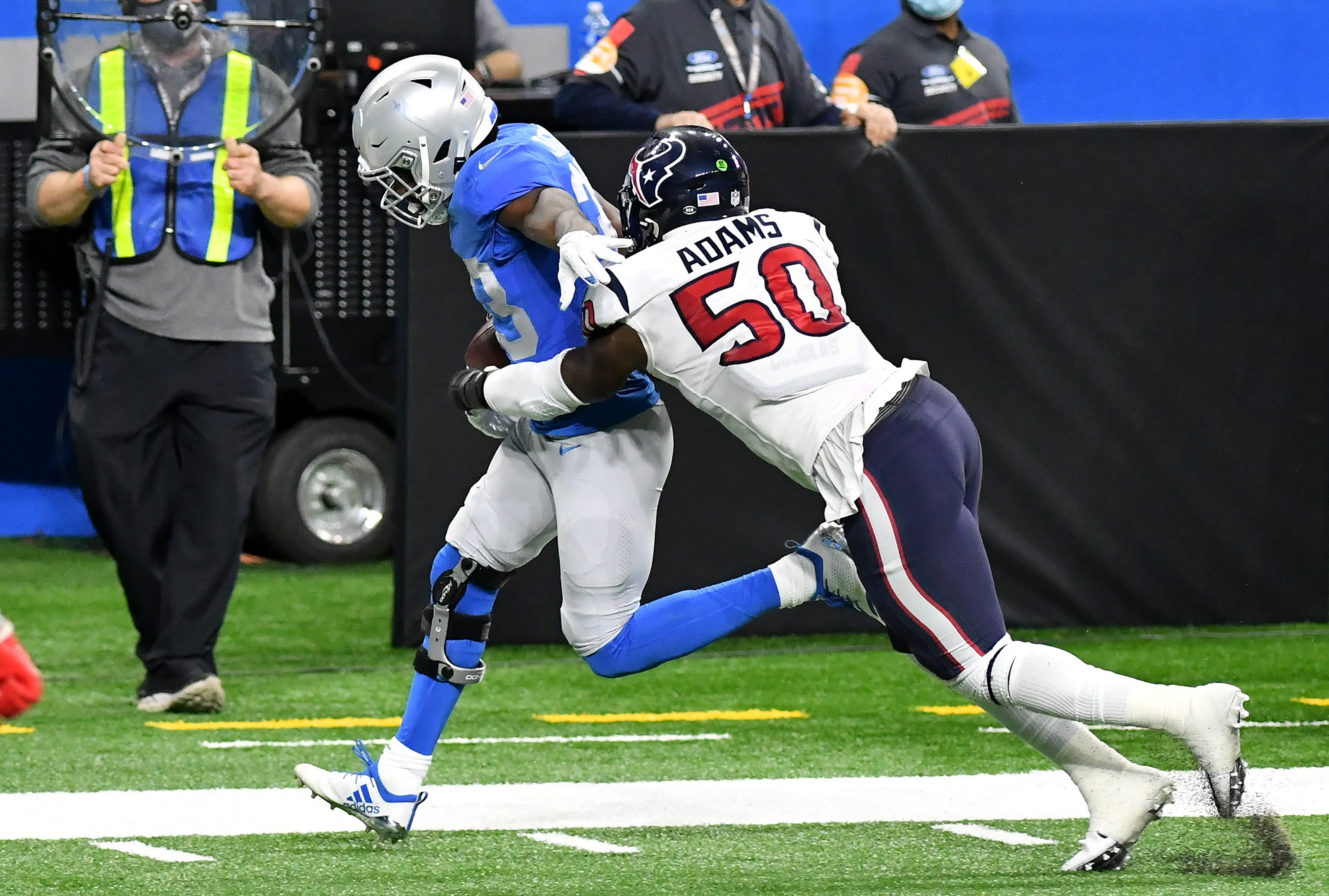 Texans linebacker Tyrell Adams (50) pushes Lions running back Kerryon Johnson (33) out of bounds  in the first half.