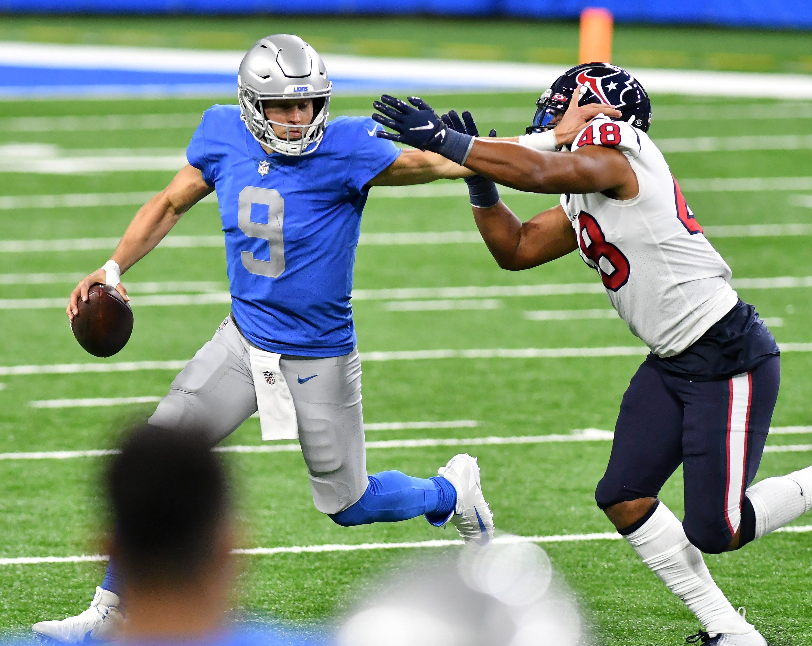 Lions quarterback Matthew Stafford (9) tries to keep Texans linebacker Nate Hall (48) at arms-length in the fourth quarter.