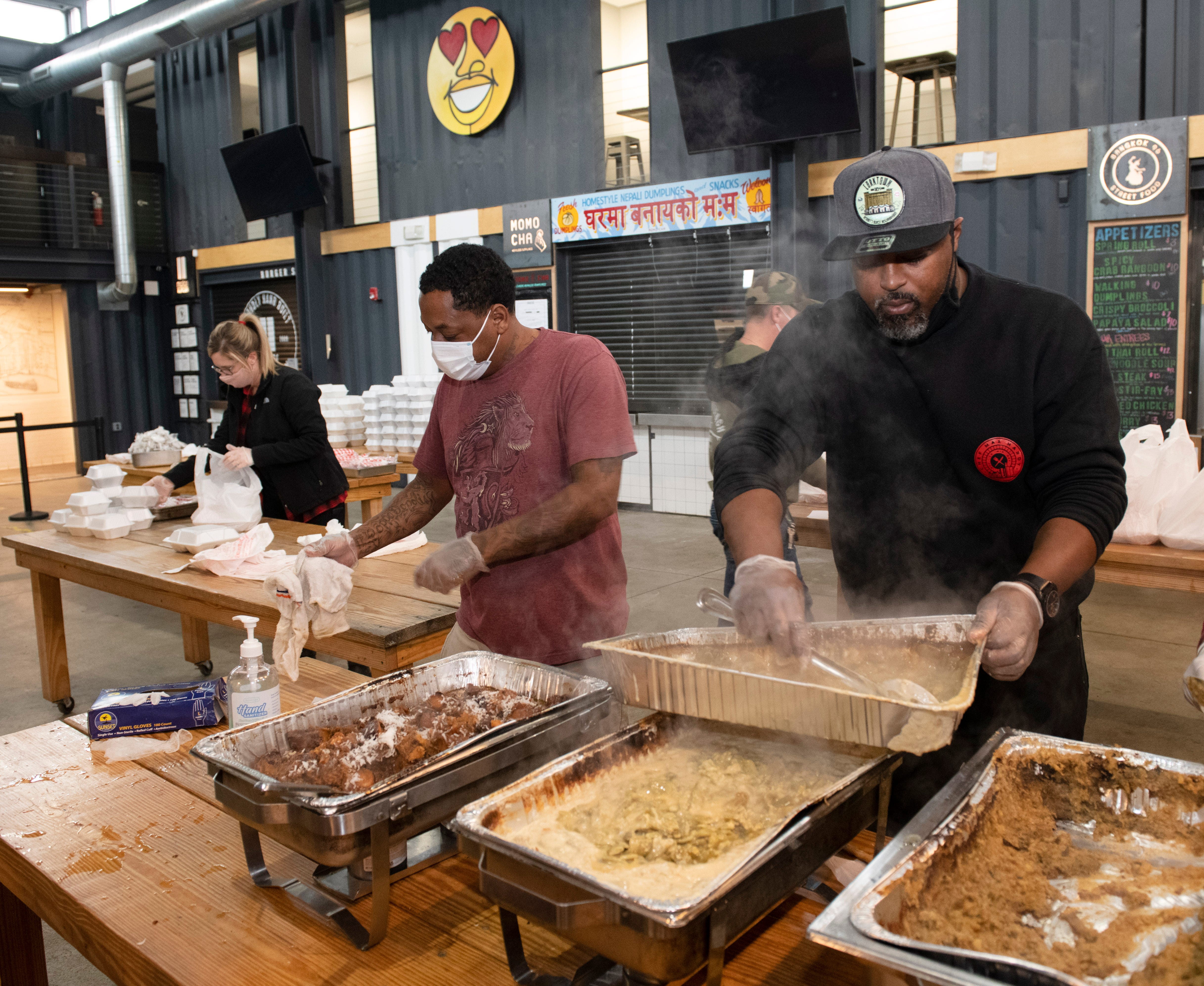 Volunteer George Tinnon, left, of Detroit and Chef Max Hardy of COOP Caribbean Fusion restaurant inside the Detroit Shipping Company, prepare and package up Thanksgiving meals for the needy on Thanksgiving Day.