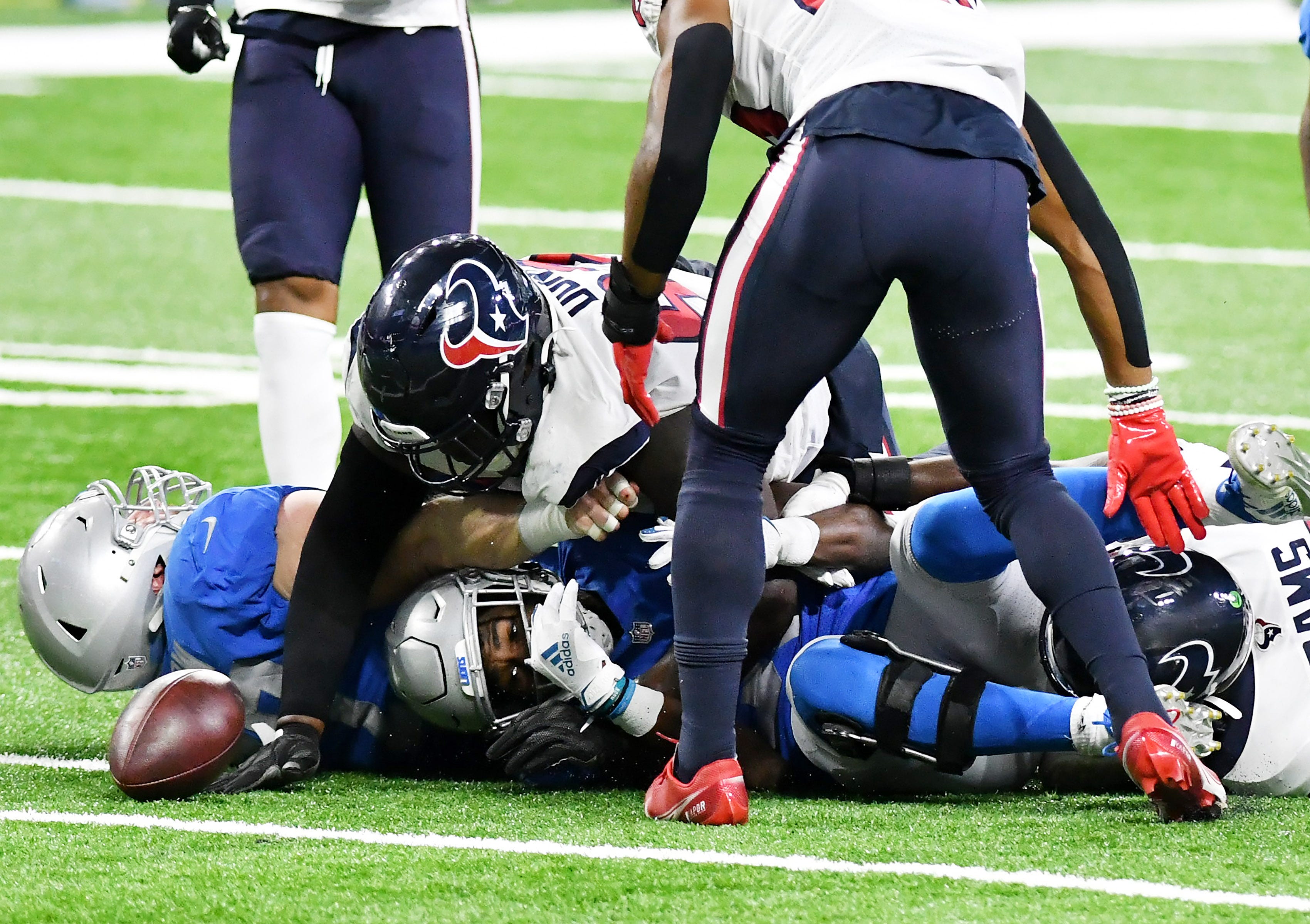Lions running back Kerryon Johnson (33) fumbles the ball and Texans nose tackle Brandon Dunn (92), on top of Johnson, about to recover in the first half. At first, the play was ruled down by contact but after a review, it was ruled a fumble.