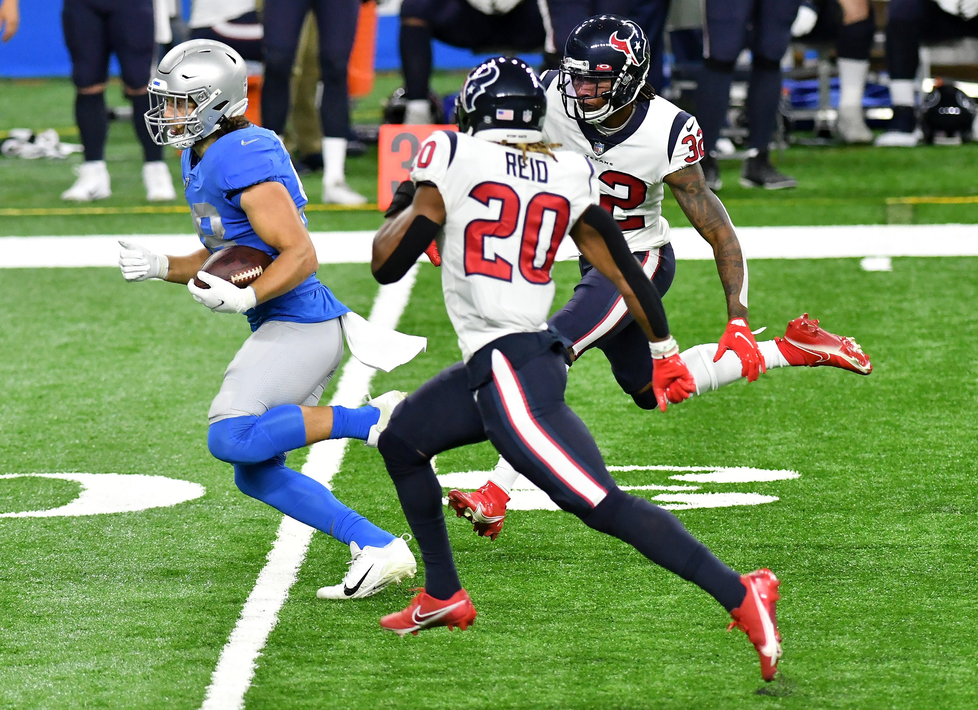 Texans cornerback Lonnie Johnson (32) and strong safety Justin Reid (20) chase Lions tight end T.J. Hockenson (88) in the first half.