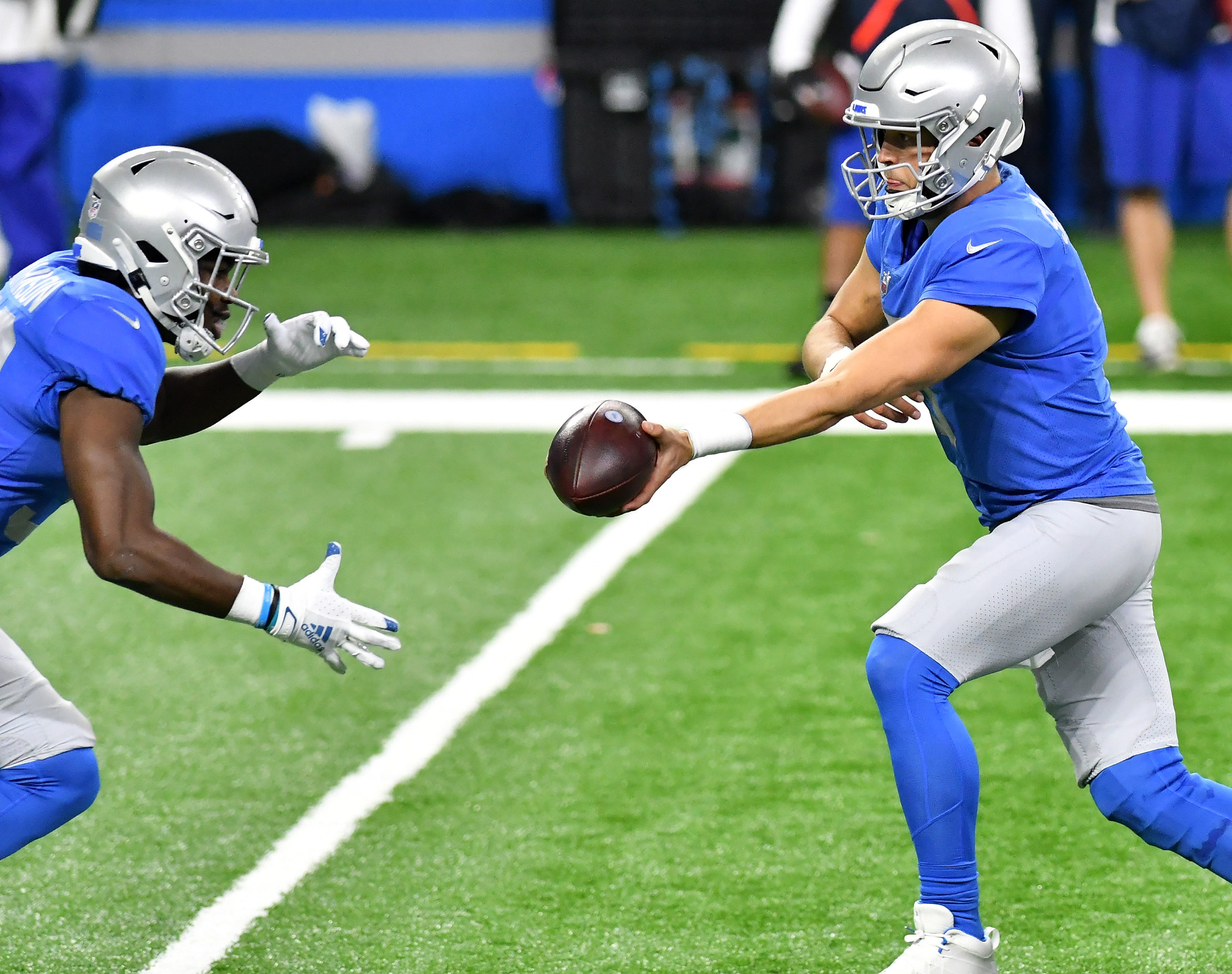 Lions quarterback Matthew Stafford (9) hands off to Lions running back Kerryon Johnson (33)  in the first half.  Detroit Lions vs Houston Texans on Thanksgiving Day at Ford Field in Detroit on Nov. 26, 2020.