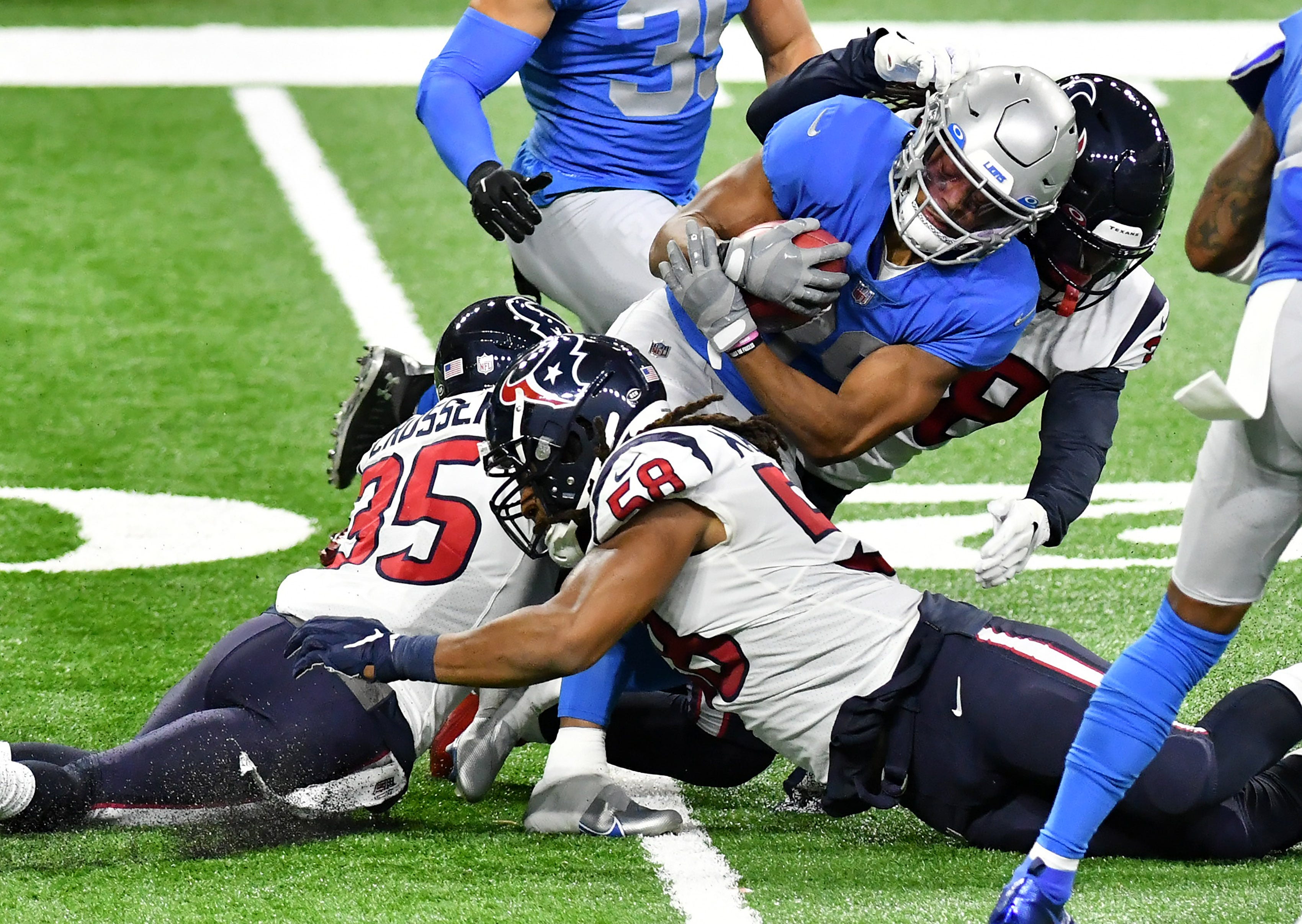 Texans cornerback Keion Crossen (35), linebacker Peter Kalambayi (58) and running back Buddy Howell (38) tackle Lions wide receiver Jamal Agnew (39)  in the first half.  Detroit Lions vs Houston Texans on Thanksgiving Day at Ford Field in Detroit on Nov. 26, 2020.