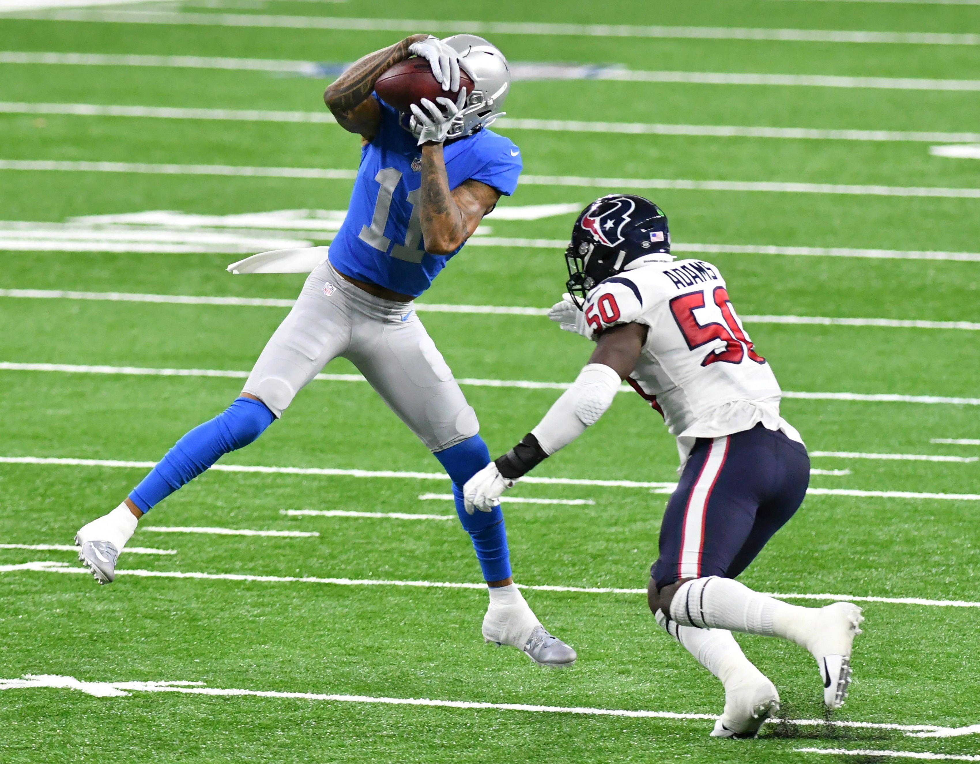 Lions wide receiver Marvin Jones Jr. (11) makes a catch in front of Texans linebacker Tyrell Adams (50) in the first half.