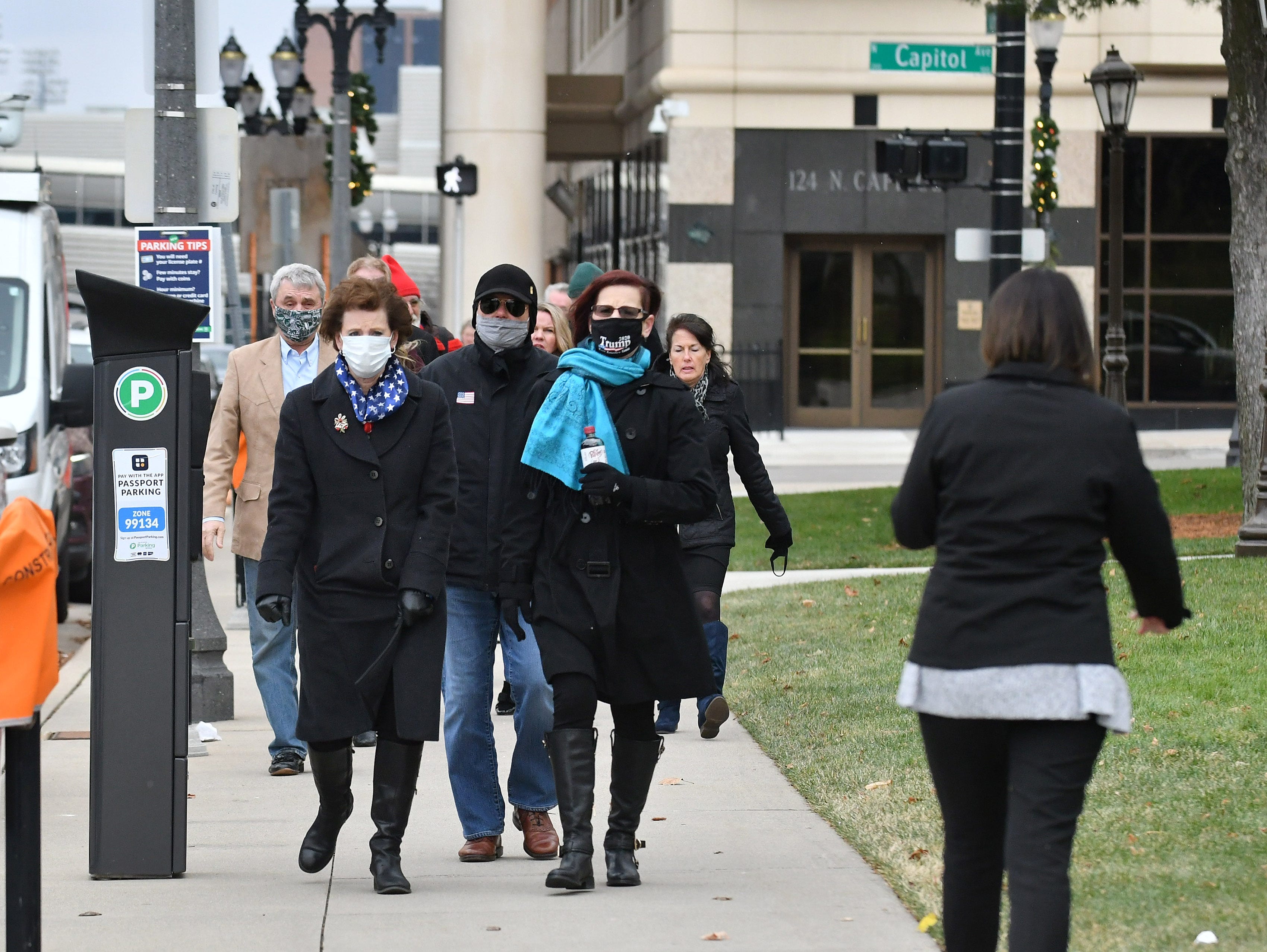 A group of Republican electors walks toward the Michigan State Capitol to try to  gain entry to cast their ballots in Lansing, Mich., on Dec. 14, 2020.