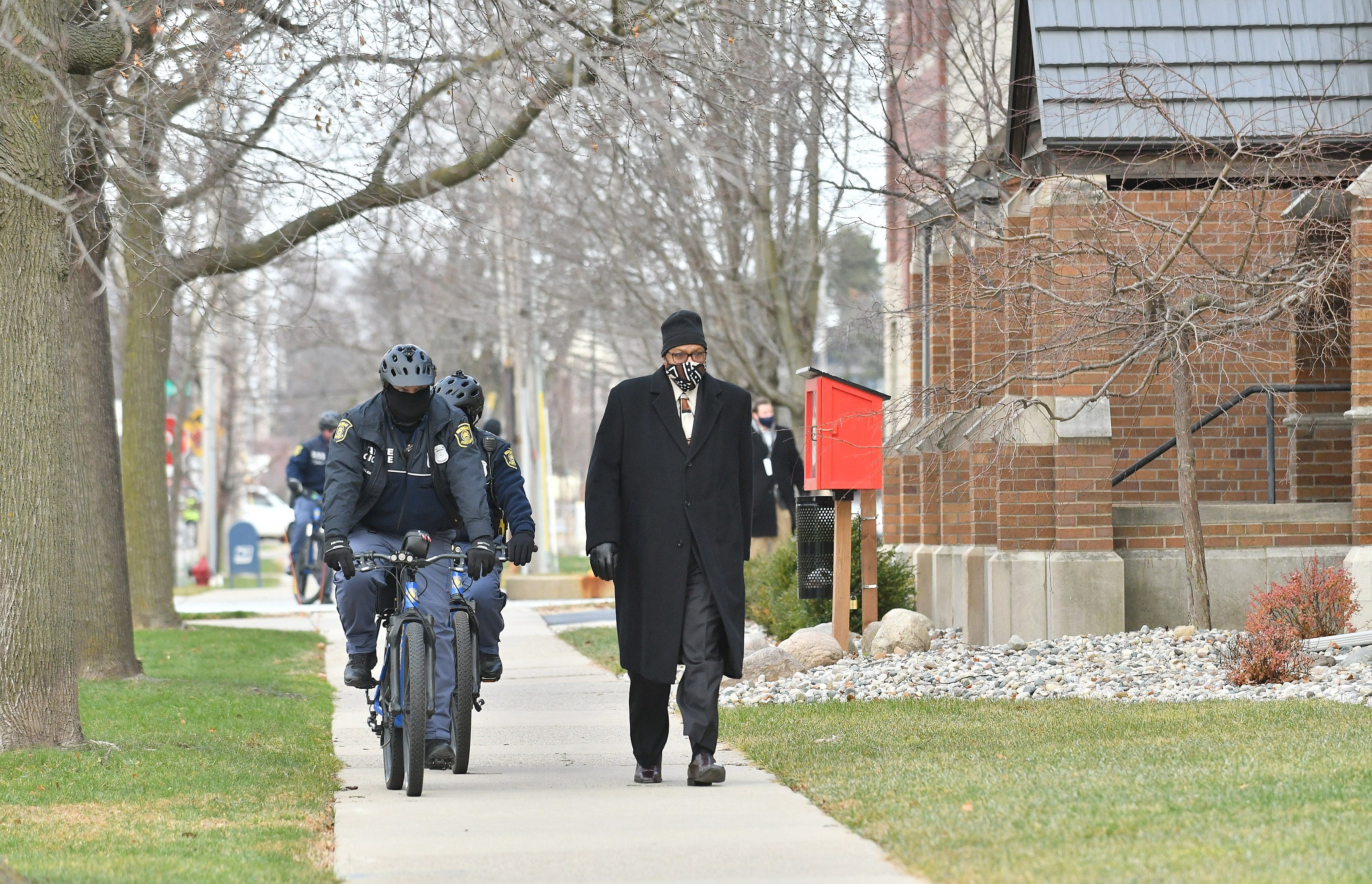 Michigan State Police officers escort Democratic elector Tim Smith from the parking garage to the Michigan State Capitol in Lansing, Mich. on Dec. 14, 2020.   The electors are casting their votes today at the capitol for the president and vice president.