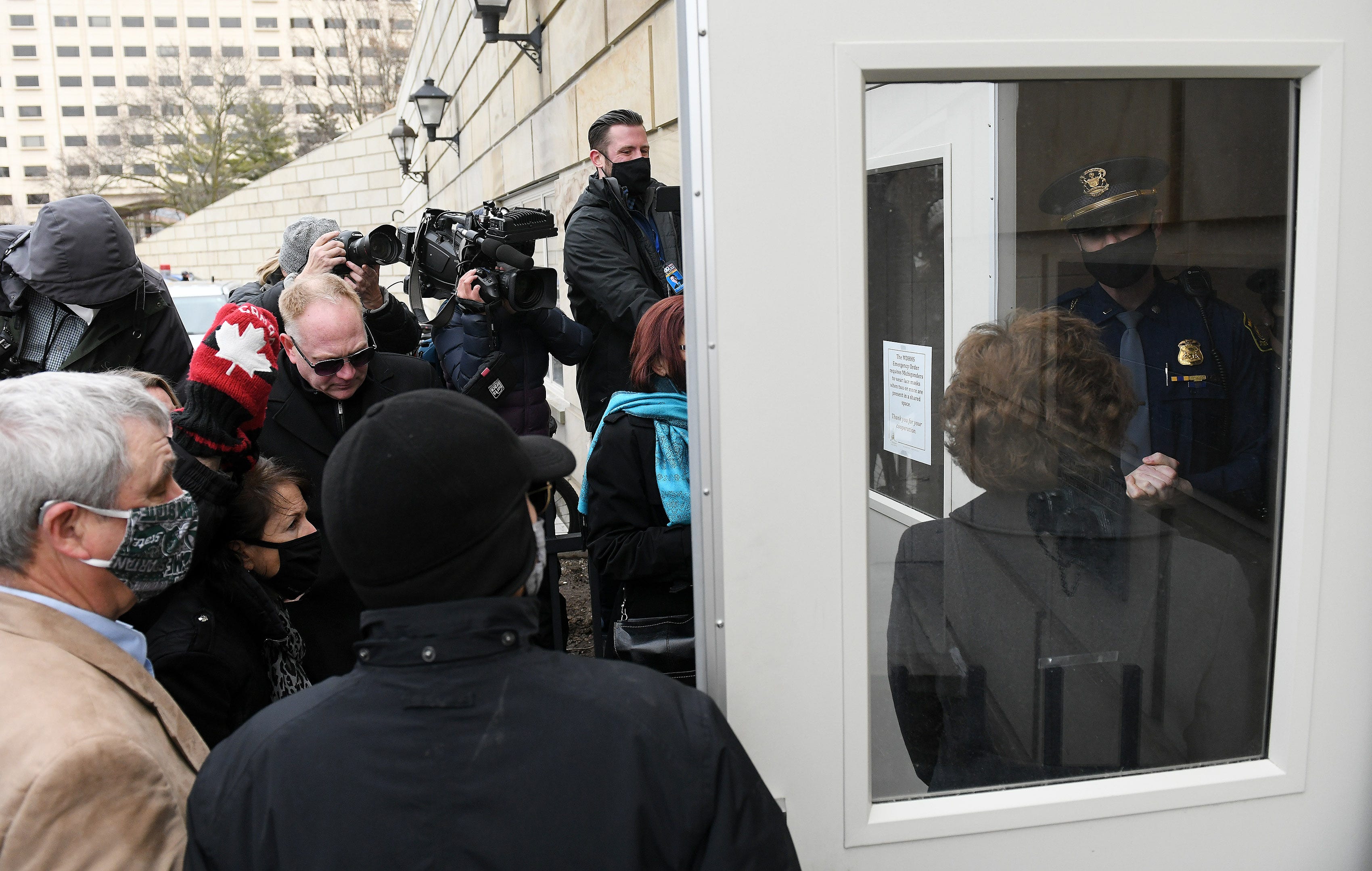 Michigan State Police officer tells state Rep. Daire Rendon, in doorway, and Republican electors that they cannot enter the Michigan State Capitol in Lansing on Dec. 14, 2020.