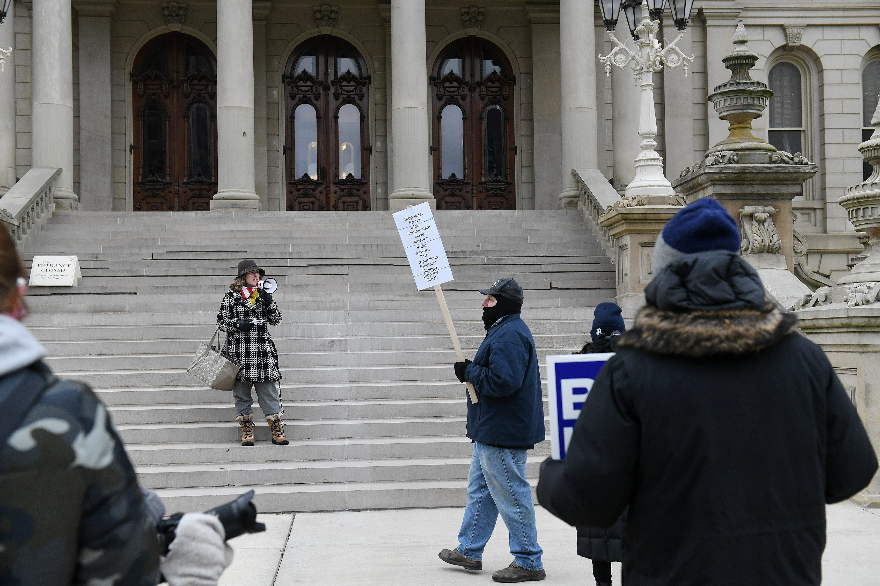 Candace Cook, 33, of Perry reads the Declaration of Independence on the steps of the Michigan State Capitol in Lansing, Mich. on Dec. 14, 2020.   The electors are casting their votes today at the capitol for the president and vice president.