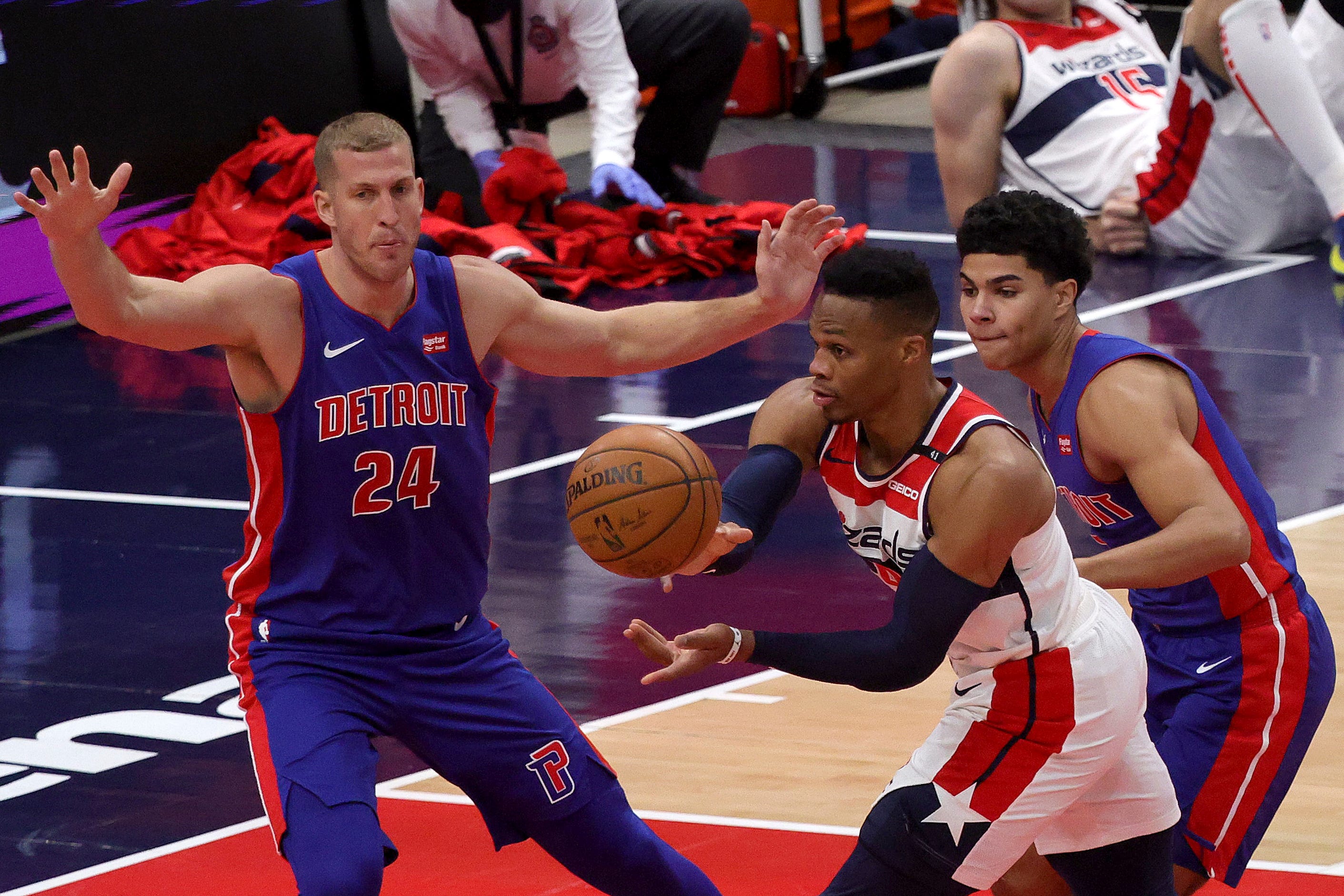 Washington Wizards Russell Westbrook (4) passes the ball between Detroit Pistons' Mason Plumlee (24) and Killian Hayes during the first half.