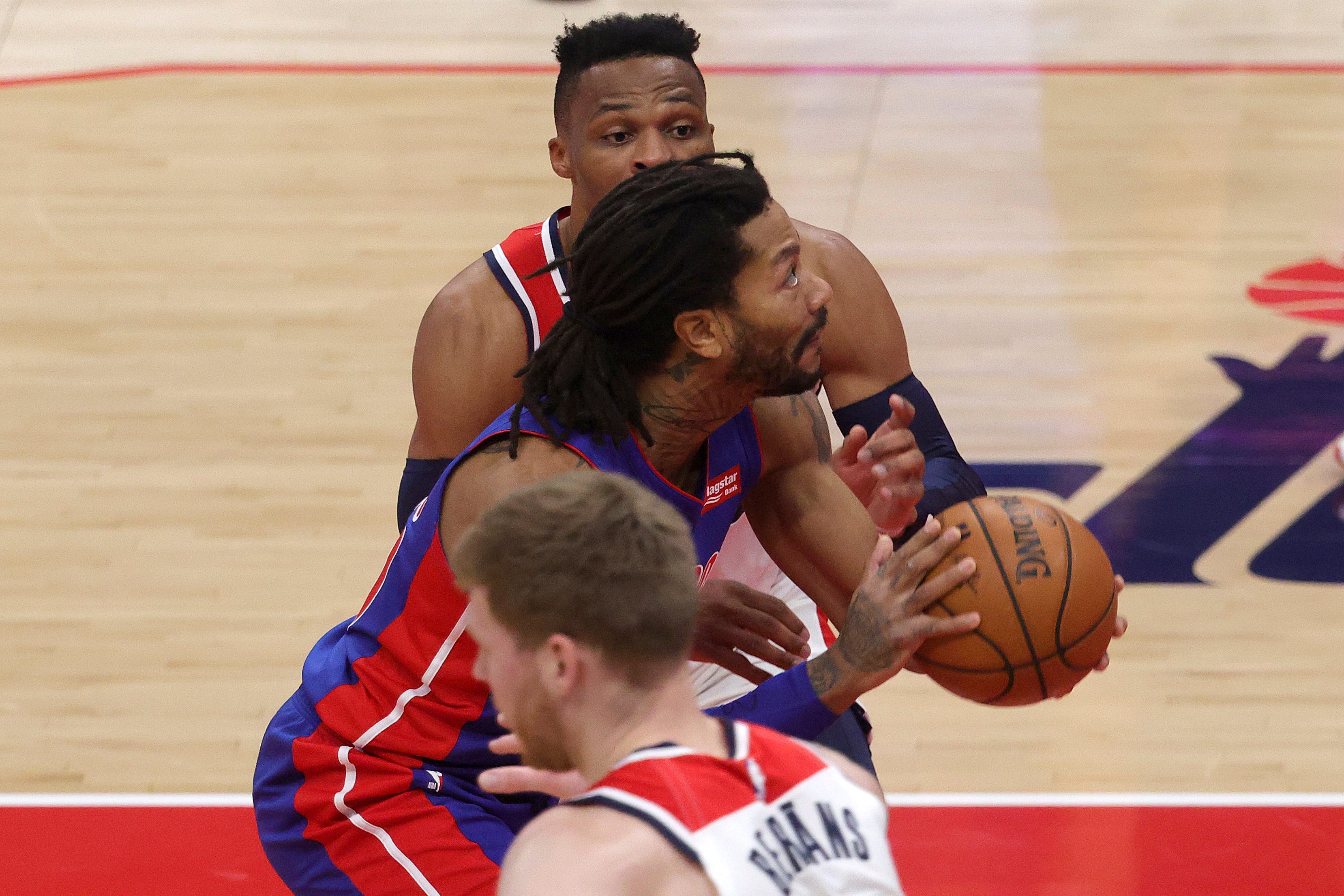 Detroit Pistons' Derrick Rose moves the ball past Washington Wizards Russell Westbrook, rear, during the first half.