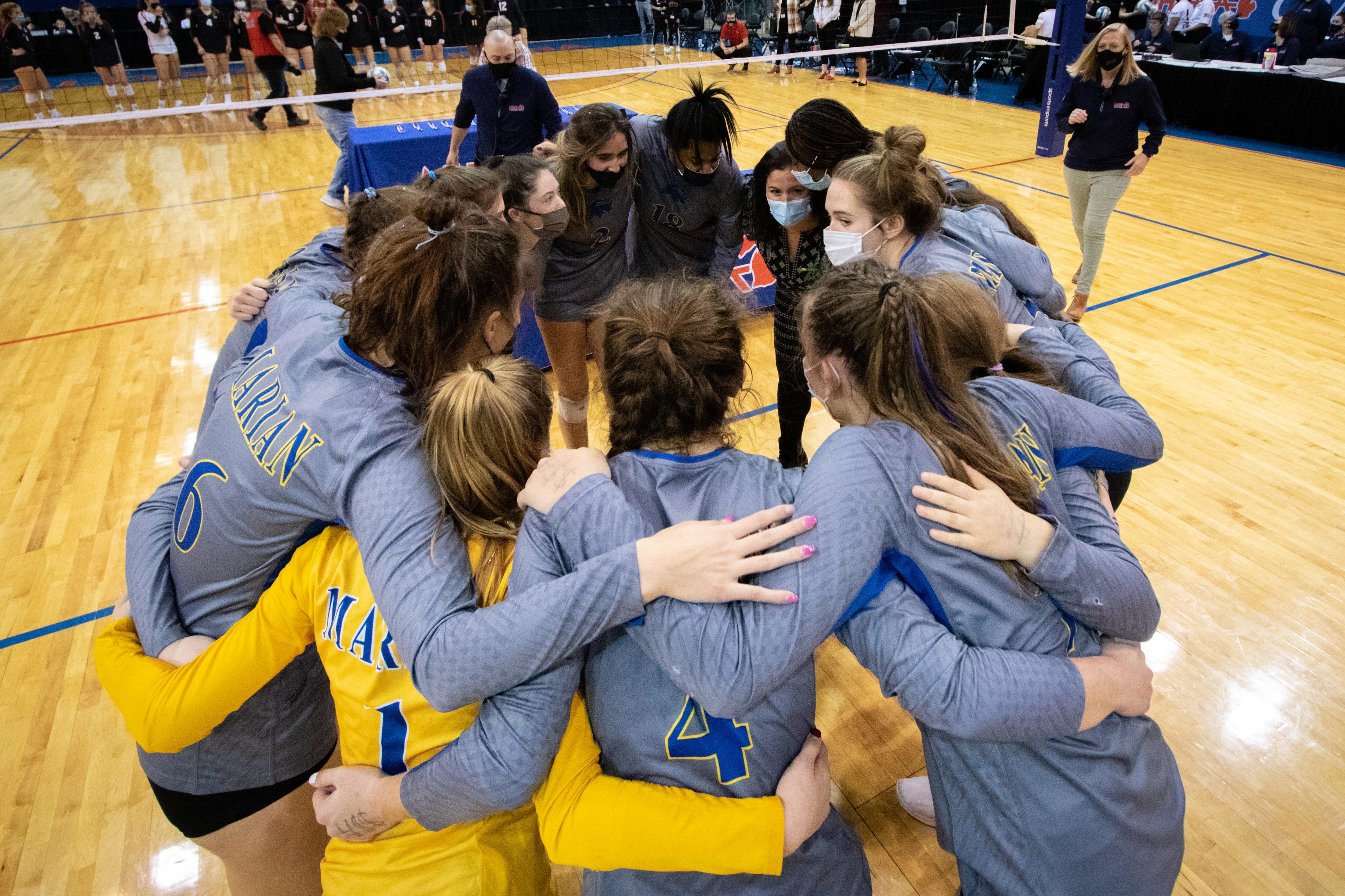 Birmingham Marian huddles together after defeating Lowell to win the Division 1 state volleyball championship on Saturday, January 16, 2021 at Kellogg Arena in Battle Creek.