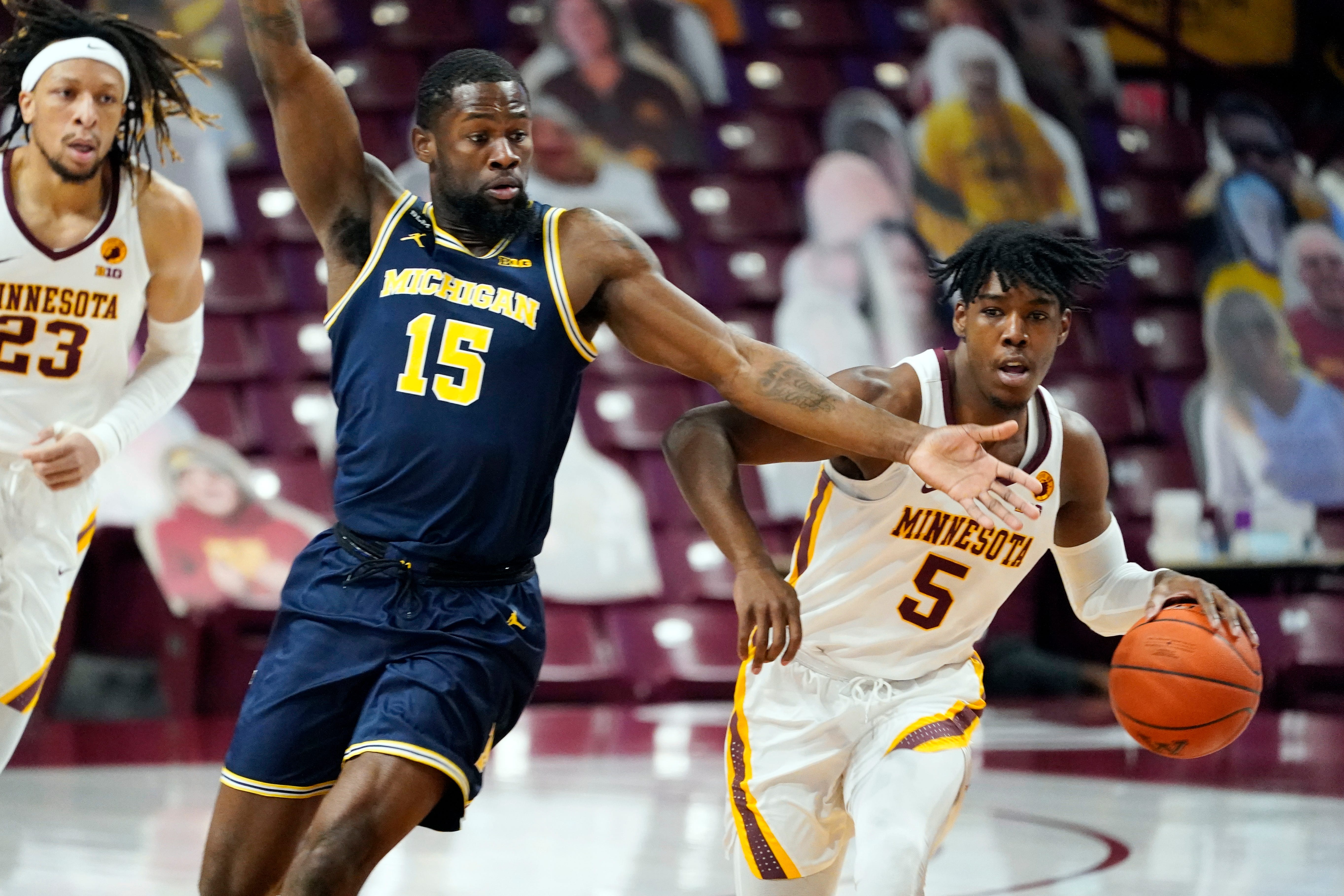 Michigan's Chaundee Brown (15) defends as Minnesota's Marcus Carr (5) drives the ball in the first half.